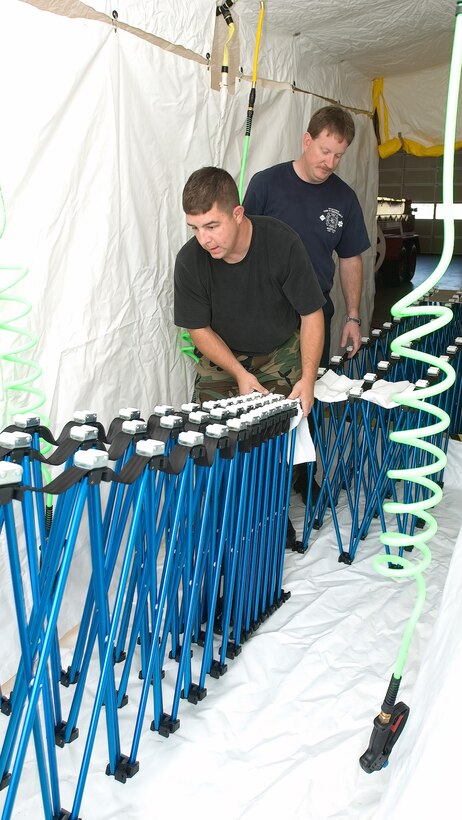 Staff Sgt. D.R. Papp and Jeff McCombs install the roller system in a three-lane decontamination shelter Nov. 2 at Dover Air Force Base, Del. The shelter is one item in a more than $230,000 equipment and training packaged provided to Dover AFB under the Defense Department Installation Protection Program Lite, also referred to as Joint Project Manager Guardian. Sergeant Papp and Mr. McCombs work in the 436th Civil Engineer Squadron fire department at Dover AFB. (U.S. Air Force photo/Jason Minto) 