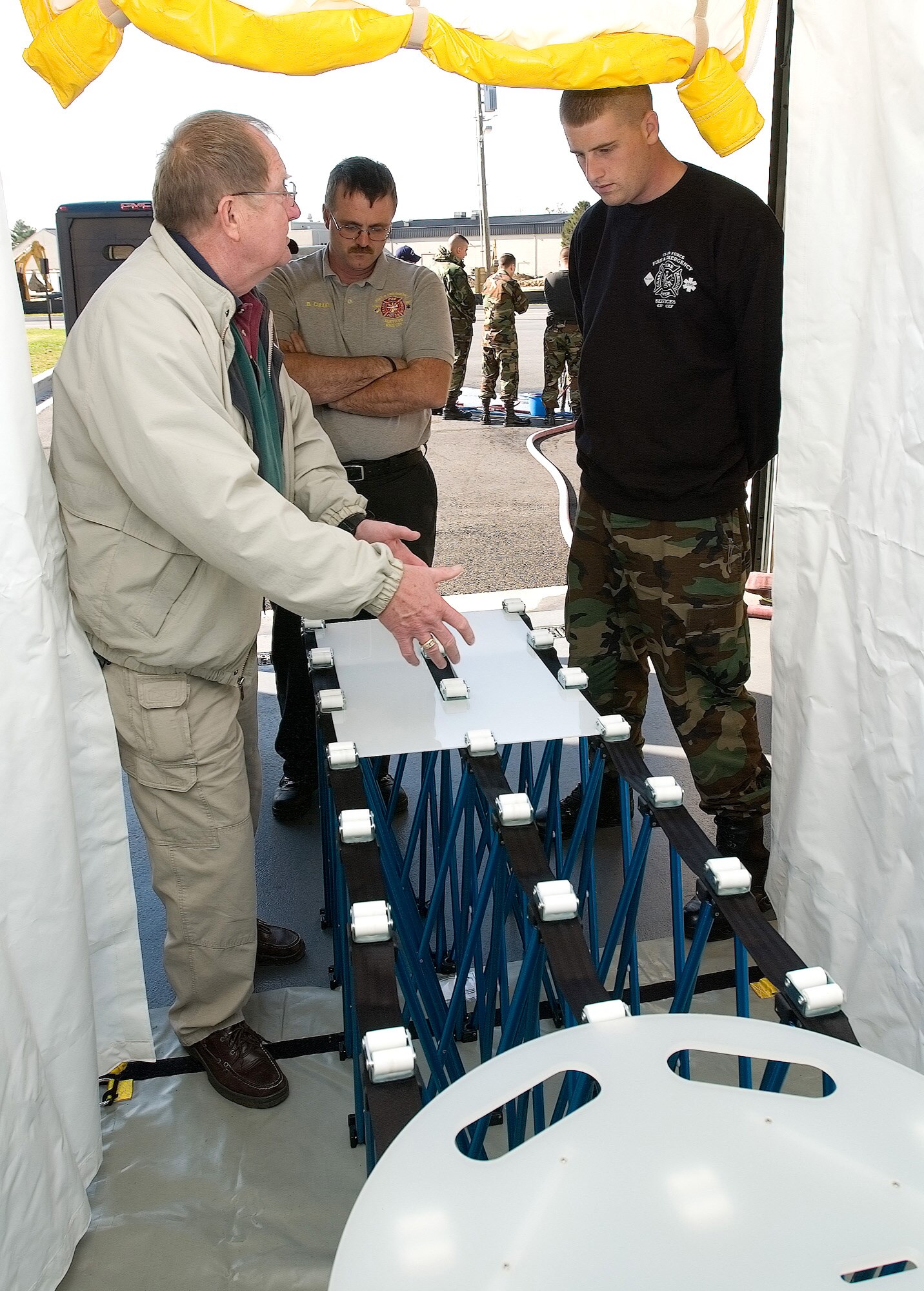 Jim Kolch explains the procedures for decontaminating non-ambulatory people to Brian Cullen and Senior Airman Kyle O'Conner during a training class Nov. 2 at Dover Air Force Base, Del. Mr. Kolch is an EAI Corporation counterterrorism with weapons of mass destruction subject matter expert assigned to the Installation Protection Program Lite. Mr. Cullen works in the 436th Civil Engineer Squadron Battalion chief of Special Operations and Airman O'Conner is a 436th CES firefighter at Dover AFB. (U.S. Air Force photo/Jason Minto)