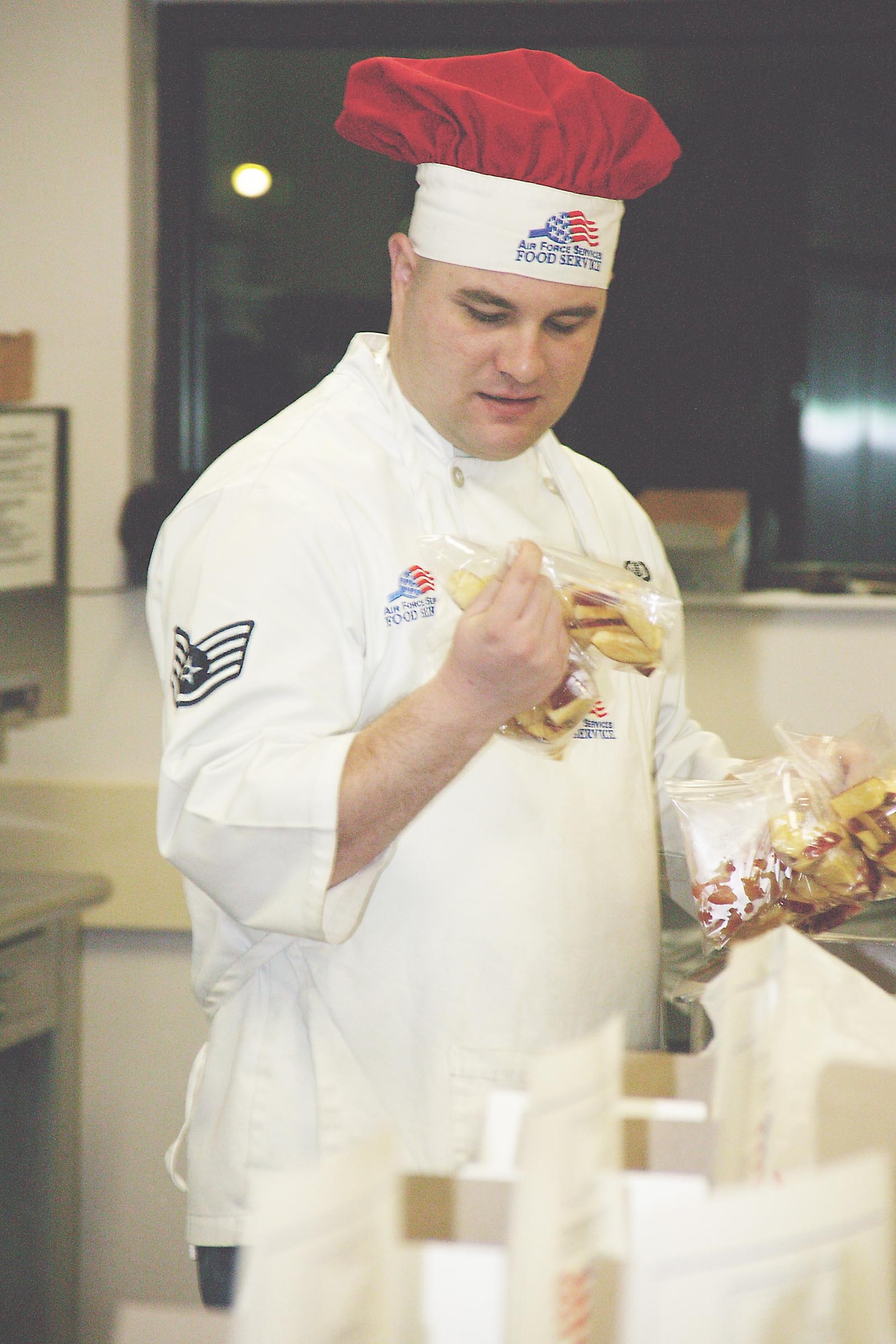 Staff Sgt. Roger Wilkins, 20th SVS dining facility shift manager, selects apple slices Monday for prepared lunches. (U.S. Air Force photo/Tarsha Storey)