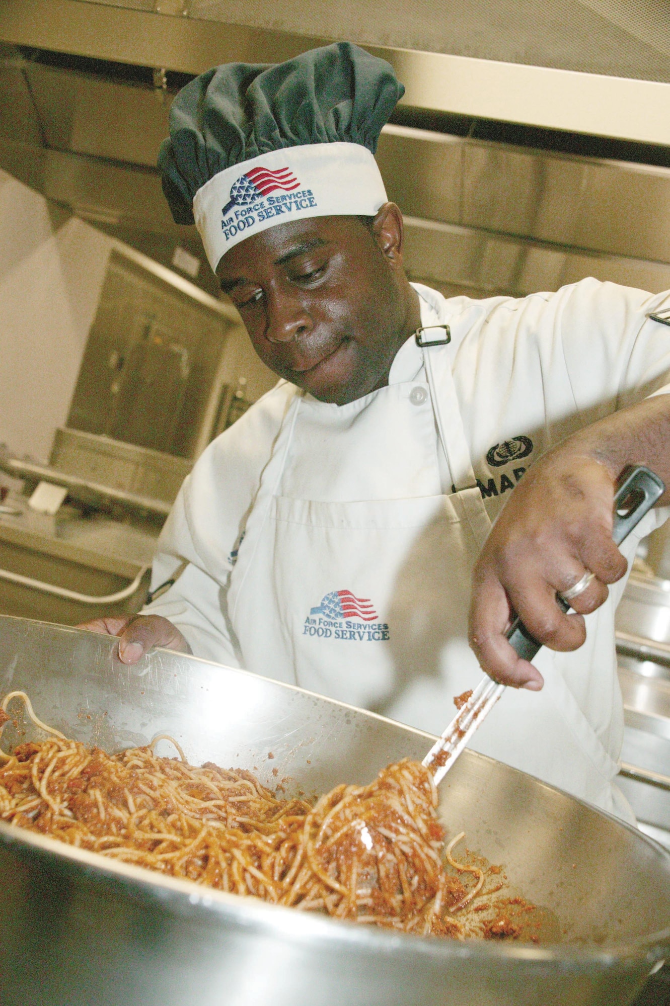 Airman 1st Class Derek Maple, 20th Services Squadron food service specialist, combines noodles and sauce to make spaghetti for the midnight meal Monday. (U.S. Air Force photo/Tarsha Storey)