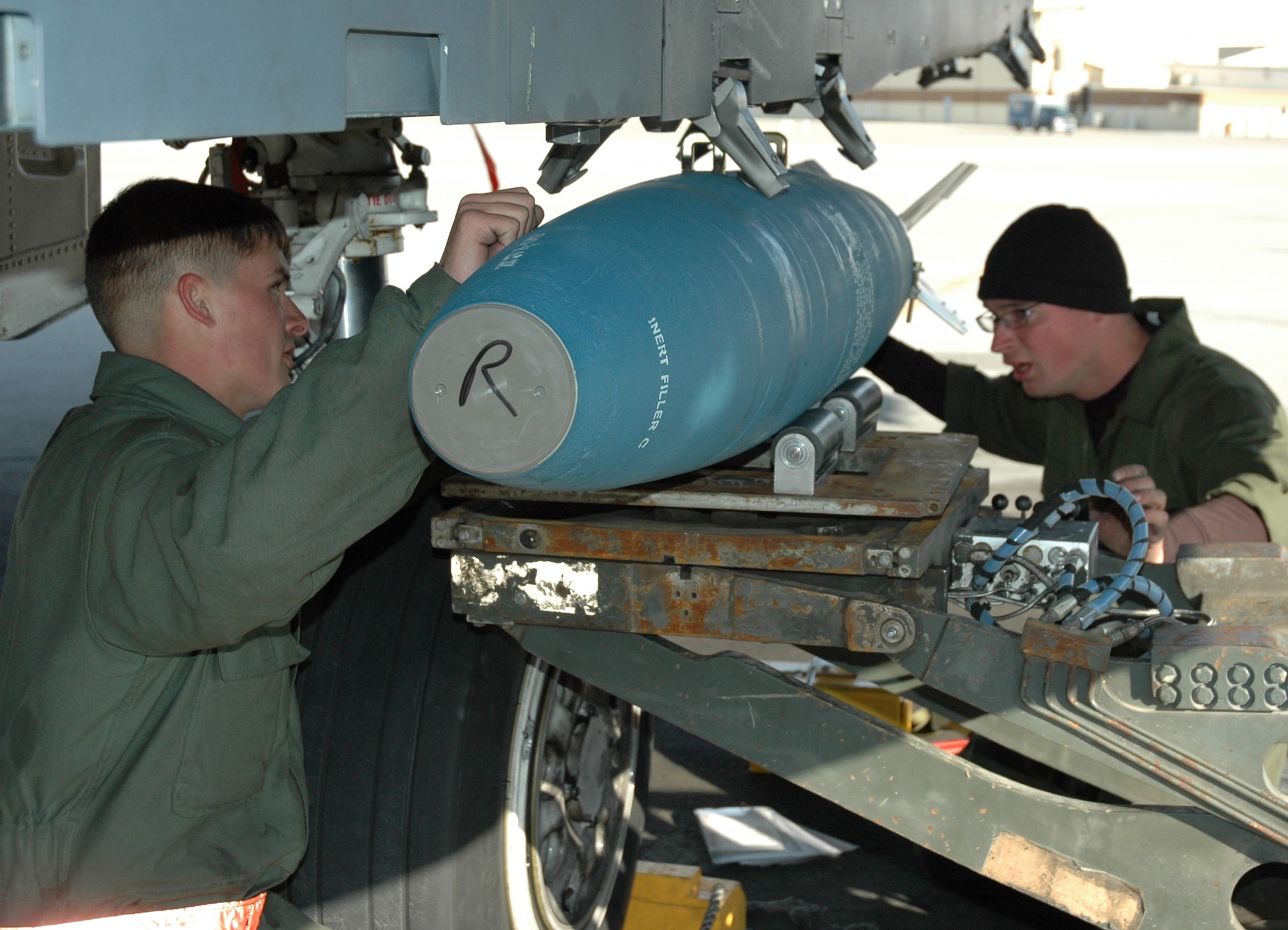 From left, Airman 1st Class Tracy Skinner and Staff Sgt. Timothy Dockens, weapons loaders with the 391st Aircraft Maintenance Unit, guide a BDU 50 practice bomb into place on one of the squadron's F-15E Strike Eagles during reload operations on the base's flightline Nov. 14. Recent upgrades to the squadron's fleet of fighters will allow the jets to carry a full array of satellite-guided weapons, including the Air Force's new small diameter bombs. Air Force photo by Master Sgt. Brian S. Orban