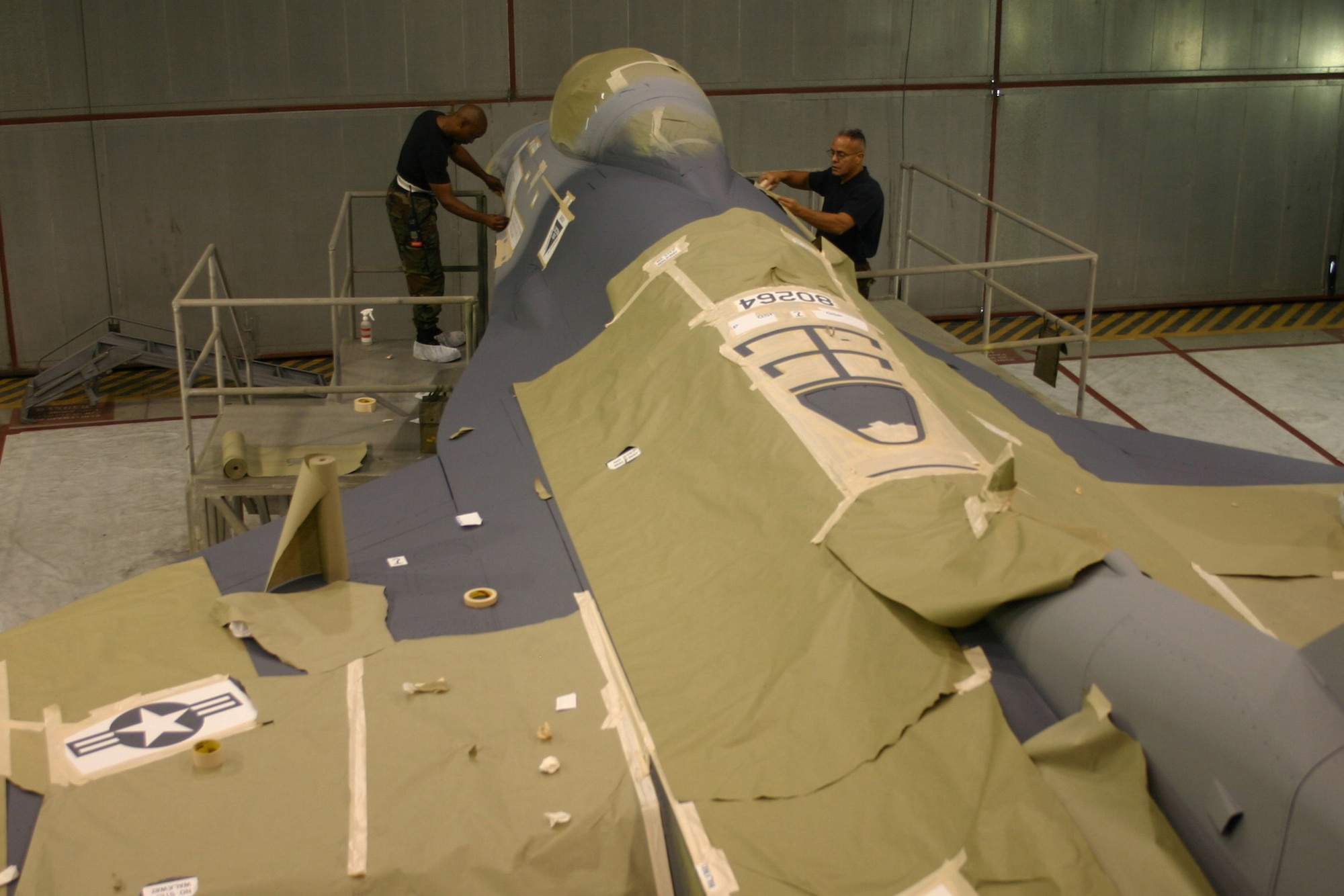 Tech. Sgt. George Walker, left, and Tech. Sgt. Luis Velez, structural maintenance technicians from the 482nd Maintenance Group, prepare stencils on an F-16 prior to painting Nov. 4 here at Homestead Air Reserve Base, Fla. (U.S. Air Force photo/Master Sgt. Ray Sarracino)
