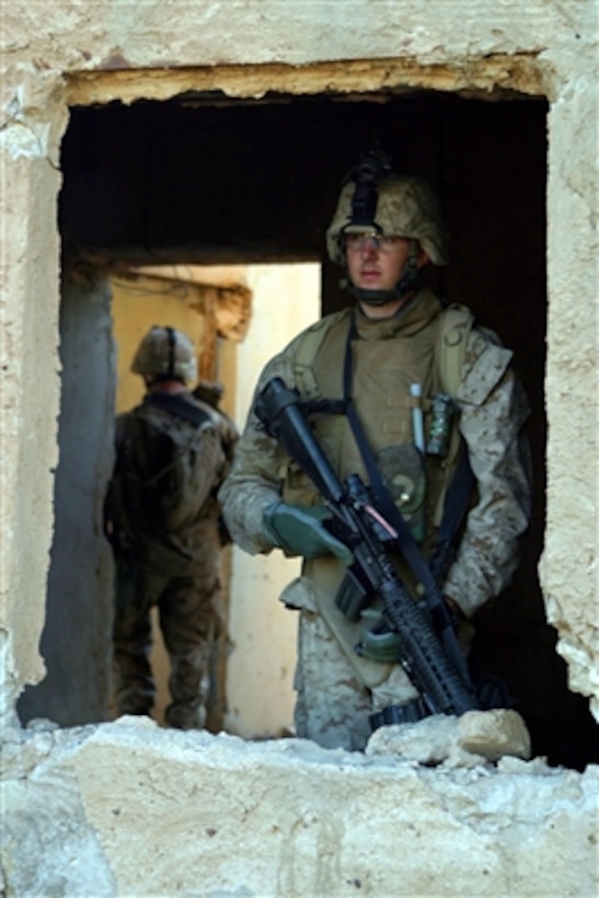 U.S. Marines from 3rd Battalion, 4th Marine Regiment provide over watch security for fellow Marines as they patrol the streets of Husaybah, Iraq, on Nov. 2, 2006. 