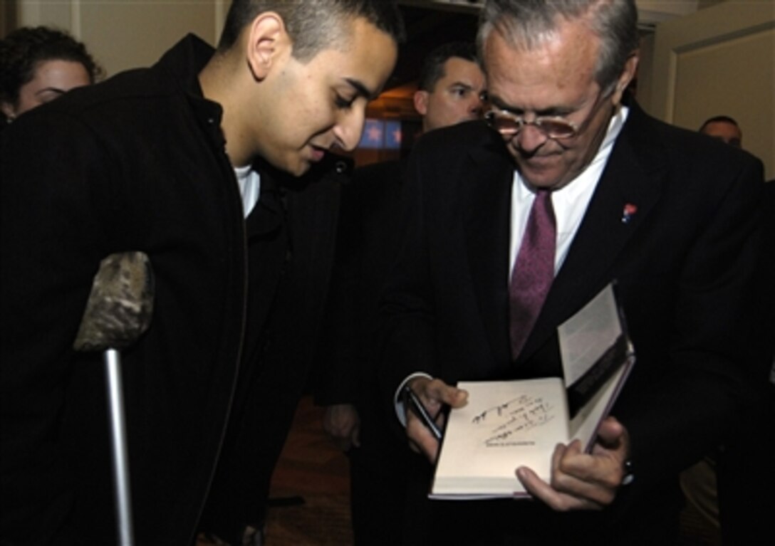 Defense Secretary Donald H. Rumsfeld signs an autograph for an injured servicemember during the American Spectator annual dinner in Washington, D.C., Nov. 15, 2006.  