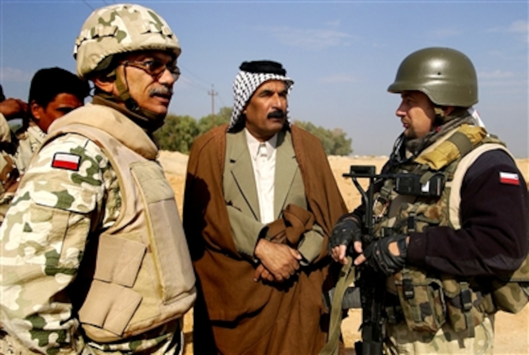 Polish army Lt. Col. Andrzej Kujawa, right, commander of the Polish Army Civil Military Cooperation Group, Multi-National Division - Central South, talks with the Beji Ahb Fmakh, center, the Sheik of Sheiks, with the help of a translator during a visit to the district of Hamza, Iraq, Nov. 10, 2006.