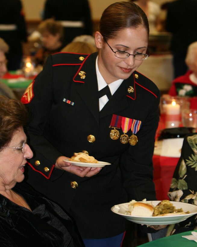 A Marine from 2nd Maintenance Battalion, 2nd Marine Logistics Group, serves lunch to a widow at the annual Military Widows Association Luncheon, held at the Jacksonville United Service Organization, Nov. 18. This is the third year that Marines have volunteered at the luncheon, escorting the widows from their cars to their tables and serving them lunch.  The annual luncheon is just one way that Marines give back to their community.