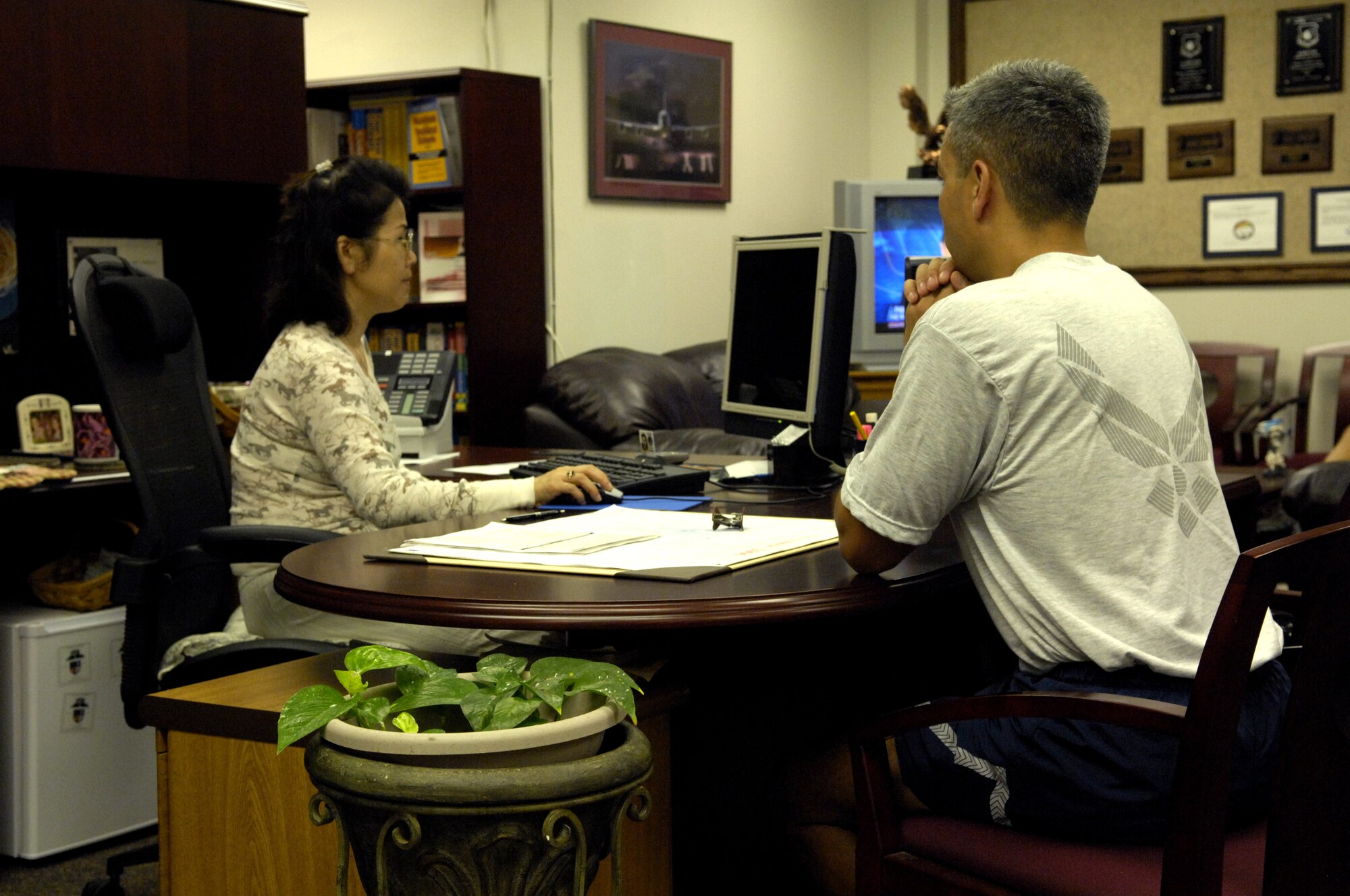 Mrs. Hyesuka Kone helps an Air Force member with his educational needs at the education center at Hickam Air Force Base, Hawaii Nov. 17, 2006. The Hickam Force Development Flight meets the educational needs of Airmen and their families assigned to the base. (U.S. Air Force Photo by Tech. Sgt. Shane A. Cuomo)
