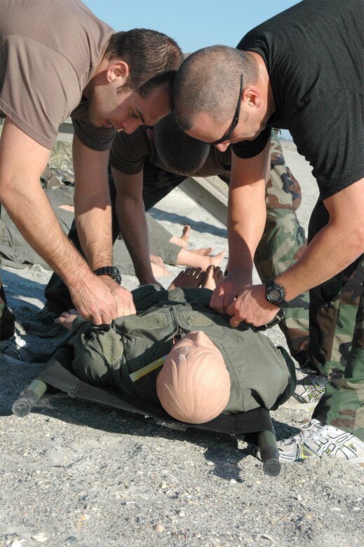 Pararescuemen from the 920th Rescue Wing work as a team to secure a mannequin to a litter on Patrick Air Force Base's beach as part of a team building exercise.  The exercise dubbed "The Monster Mash" was built by various members of the 308th Rescue Squadron to build camaraderie and put the pararescuemen through obstacles that test their strength, endurance, team-building and medical skills as well as other pararescue training.  The Monster Mash is held on a quarterly basis by the squadron.