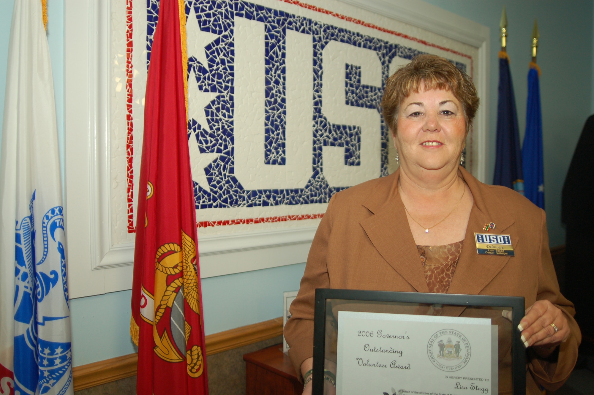Lisa Stagg, Delaware United Services Organization Center manager, shows off her certificate for the Delaware Governor's Outstanding Volunteer Service Award for her service to military personnel from every branch of the service transiting the Dover Air Force Base Passenger's Terminal to destinations around the world. (U.S. Air Force photo/1st Lt. Chris Sukach) 