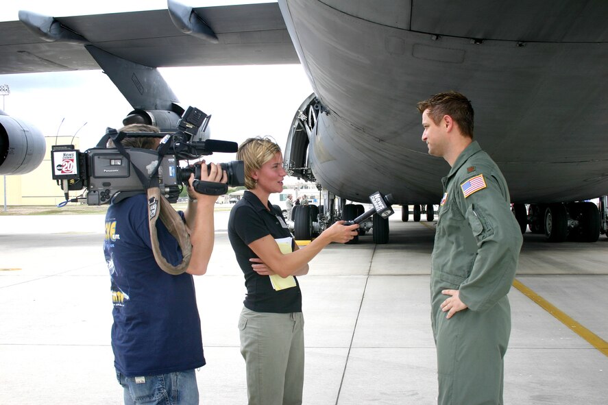 Air Force Reserve pilot, Major Jeff Schmidt, 68th Airlift Squadron, Lackland AFB, TX, (right), tells an Illinois-based television news reporter about the dynamics of operating the nation's largest military transport plane, the C-5 Galaxy.  The two-person news crew was part of an Illinois Employer Support for the Guard and Reserve group tour that visited the 433rd Airlift "Alamo" Wing located in San Antonio, Texas, July '06.