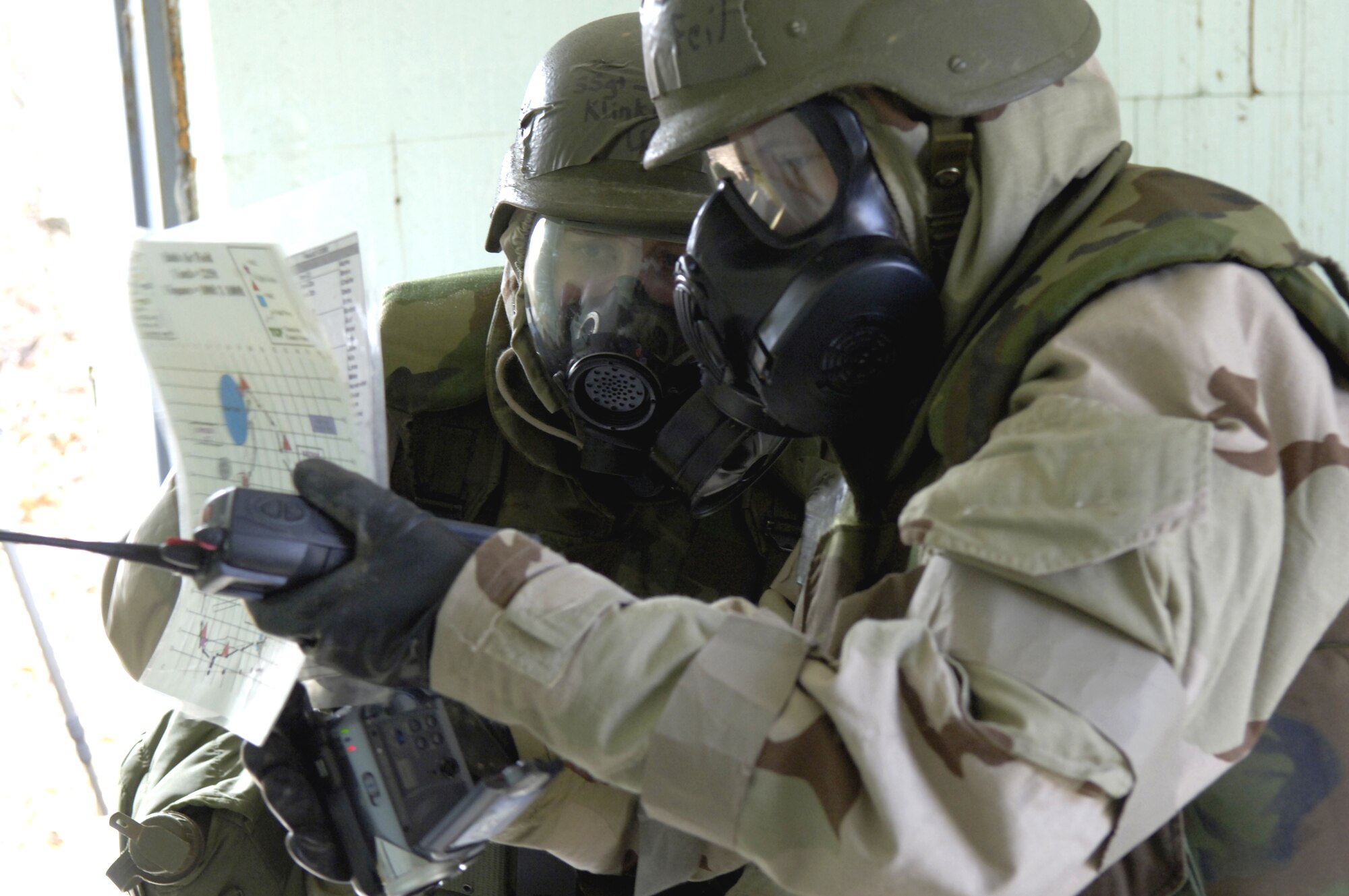 Staff Sgts. Jenna Klinkenberg (left) and Jessica Feil look over their notes while performing a site survey of a potentially contaminated room Nov. 16.  The survey was part of a readiness training exercise at Fort Leonard Wood, Mo. The exercise is designed to give readiness Airmen training scenarios developed from lessons learned during operations Iraqi Freedom and Enduring Freedom. The two-day exercise is the part of a two-week training class here. Sergeant Klinkenberg is with the 3rd Civil Engineer Squadron, Elmendorf Air Force Base, Alaska, and Sergeant Feil is with Detachment 1, 823rd Red Horse, Tyndall AFB, Fla.  (U.S. Air Force photo/Senior Airman Brian Ferguson) 