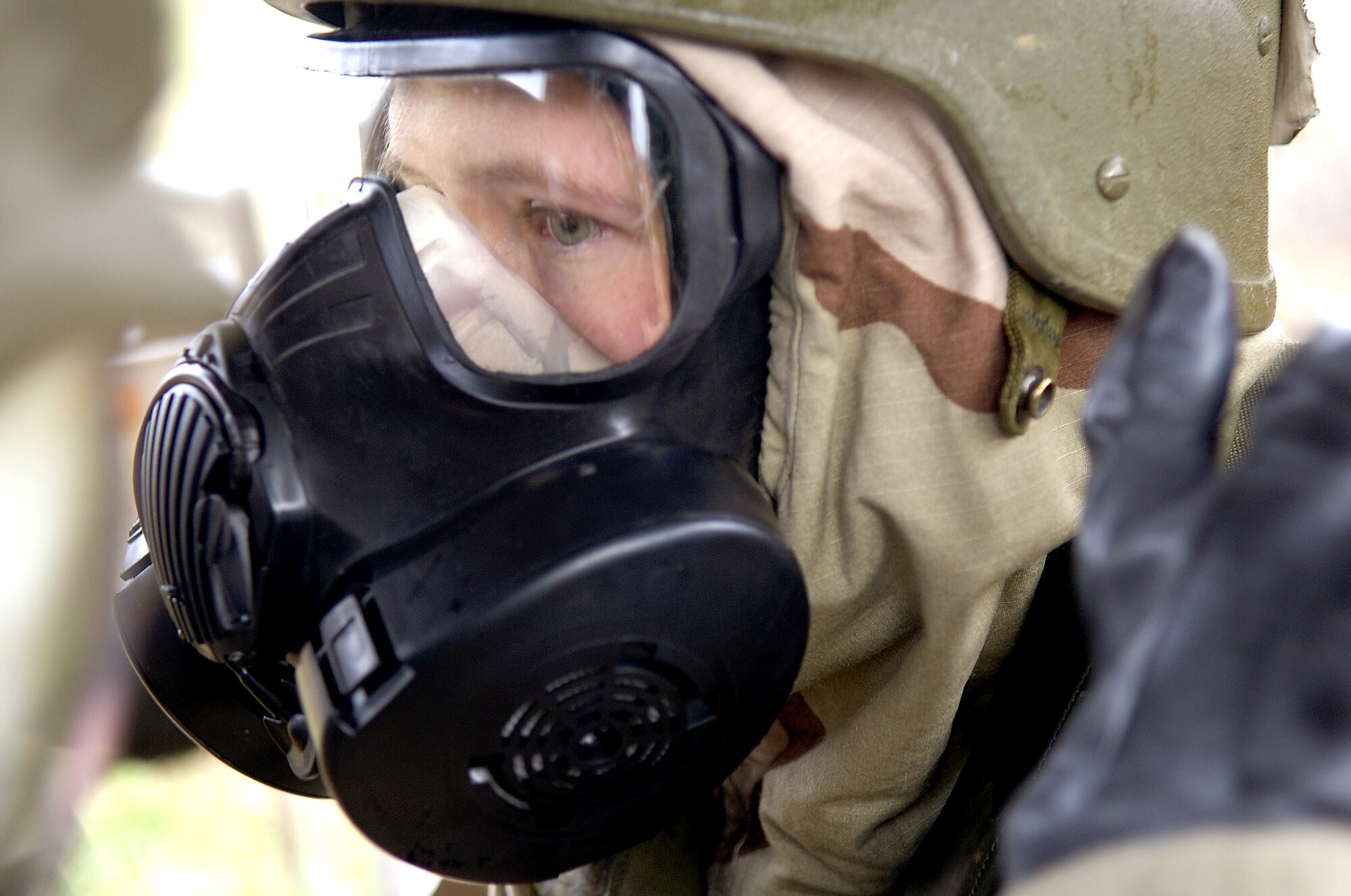 Staff Sgt. Jessica Feil dons a mask Nov. 16 during a readiness exercise at Fort Leonard Wood, Mo. The exercise is designed to give readiness Airmen training scenarios developed from lessons learned during operations Iraqi Freedom and Enduring Freedom. The two-day exercise is the part of a two-week training class here. Sergeant Feil is a readiness technician with Detachment 1, 823rd Red Horse, Tyndall Air Force Base, Fla.  (U.S. Air Force photo/Senior Airman Brian Ferguson) 
