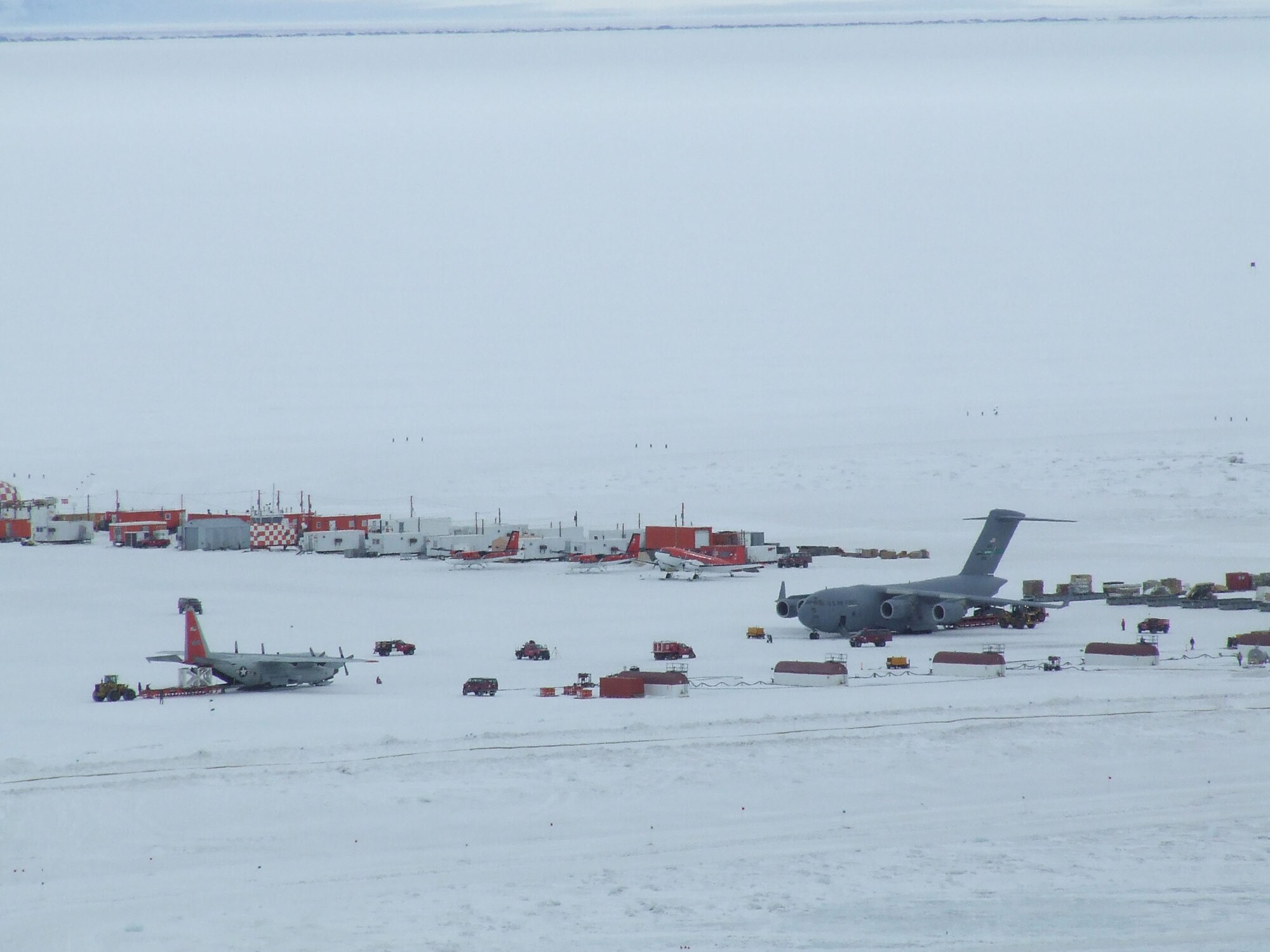 MCMURDO STATION, Antarctica - Cargo is transported from a McChord C-17 Globemaster III to an awaiting LC-130 Hercules operated by the New York Air National Guard Nov. 14, 2006, near here. U.S. Air Force Photo/ By 1st Lt Erika Yepsen