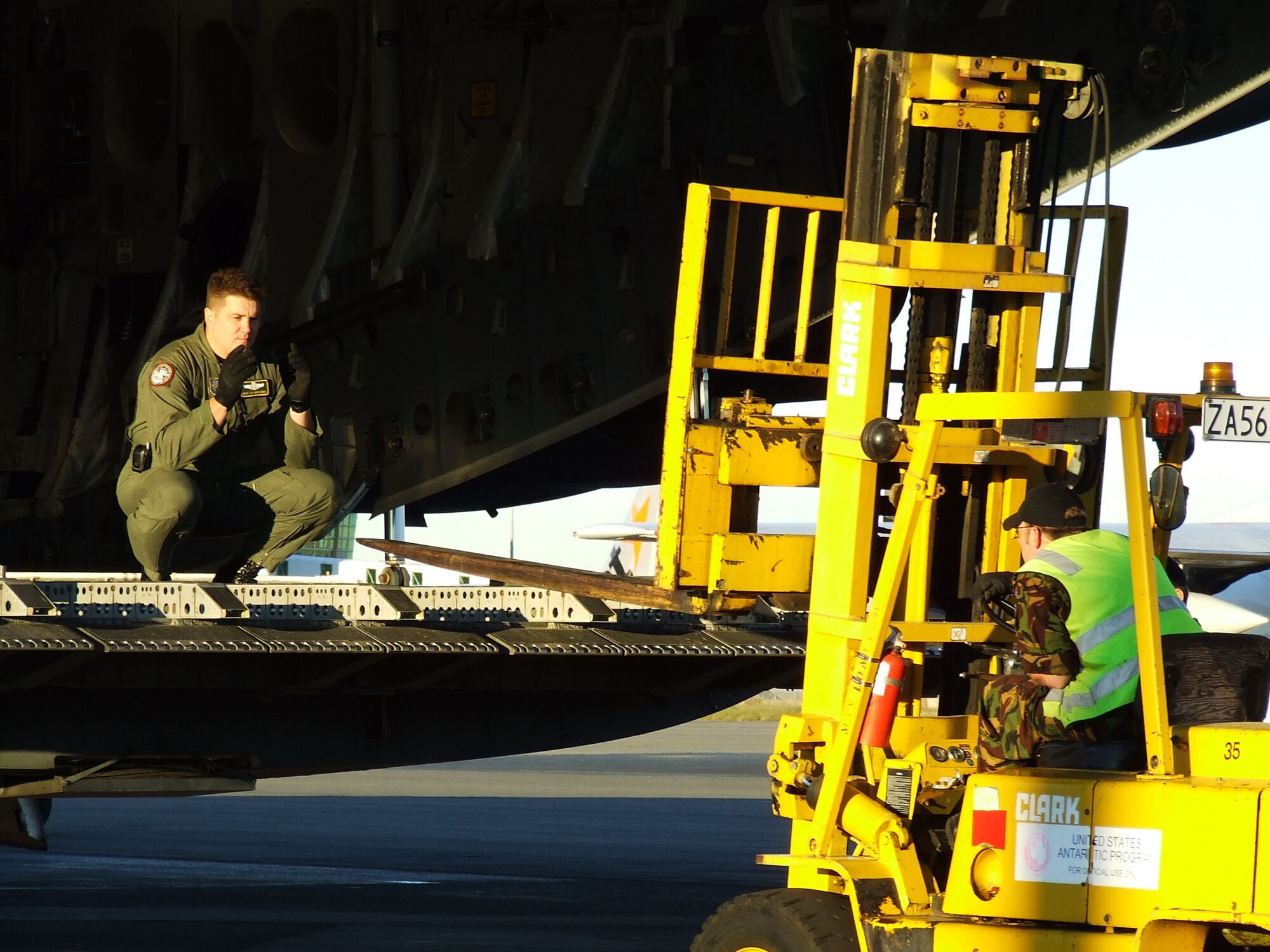 CHRISTCHURCH, New Zealand - Master Sgt J.D. Bartlemus, 62nd Operations Group, directs a Royal New Zealand Air Force forklift driver as he prepares to off-load pallet seats Nov. 13, 2006, to make room for cargo bound for Antarctica. U.S. Air Force Photo/ By 1st Lt Erika Yepsen