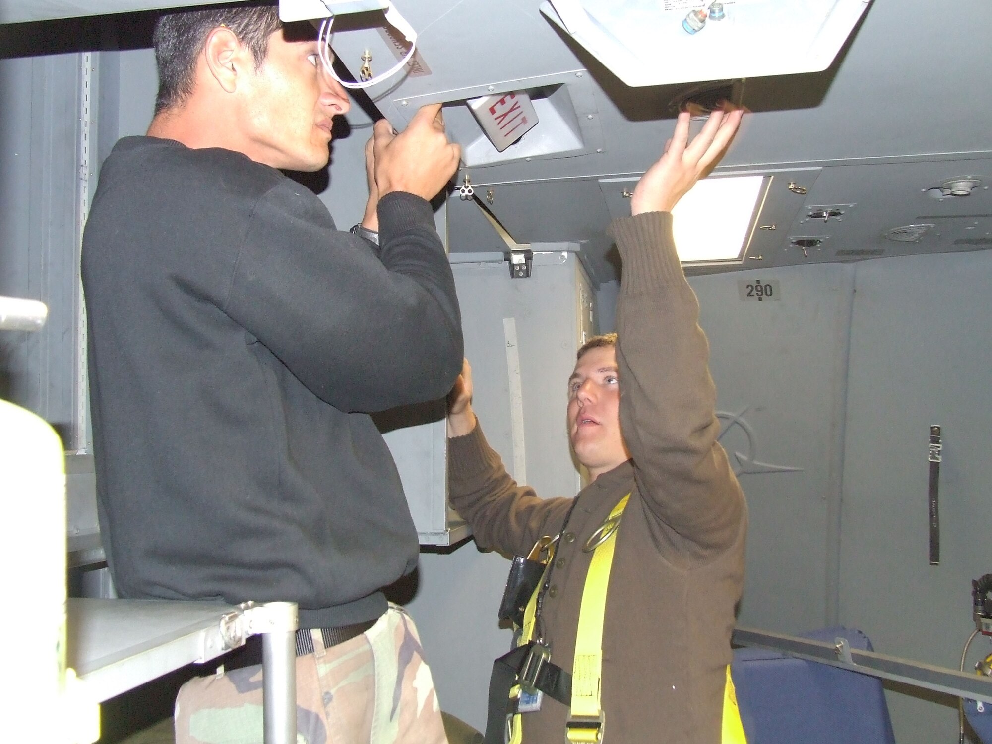 CHRISTCHURCH, New Zealand - From left, Staff Sgt. Andrew Johnson, 62nd Aircraft Maintenance Squadron, and Airman 1st Class David Demarist remove a ceiling panel in the cockpit of a McChord C-17 Globemaster III Nov. 13, 2006, in preparation for its flight to Antarctica. U.S. Air Force Photo/ By 1st Lt Erika Yepsen