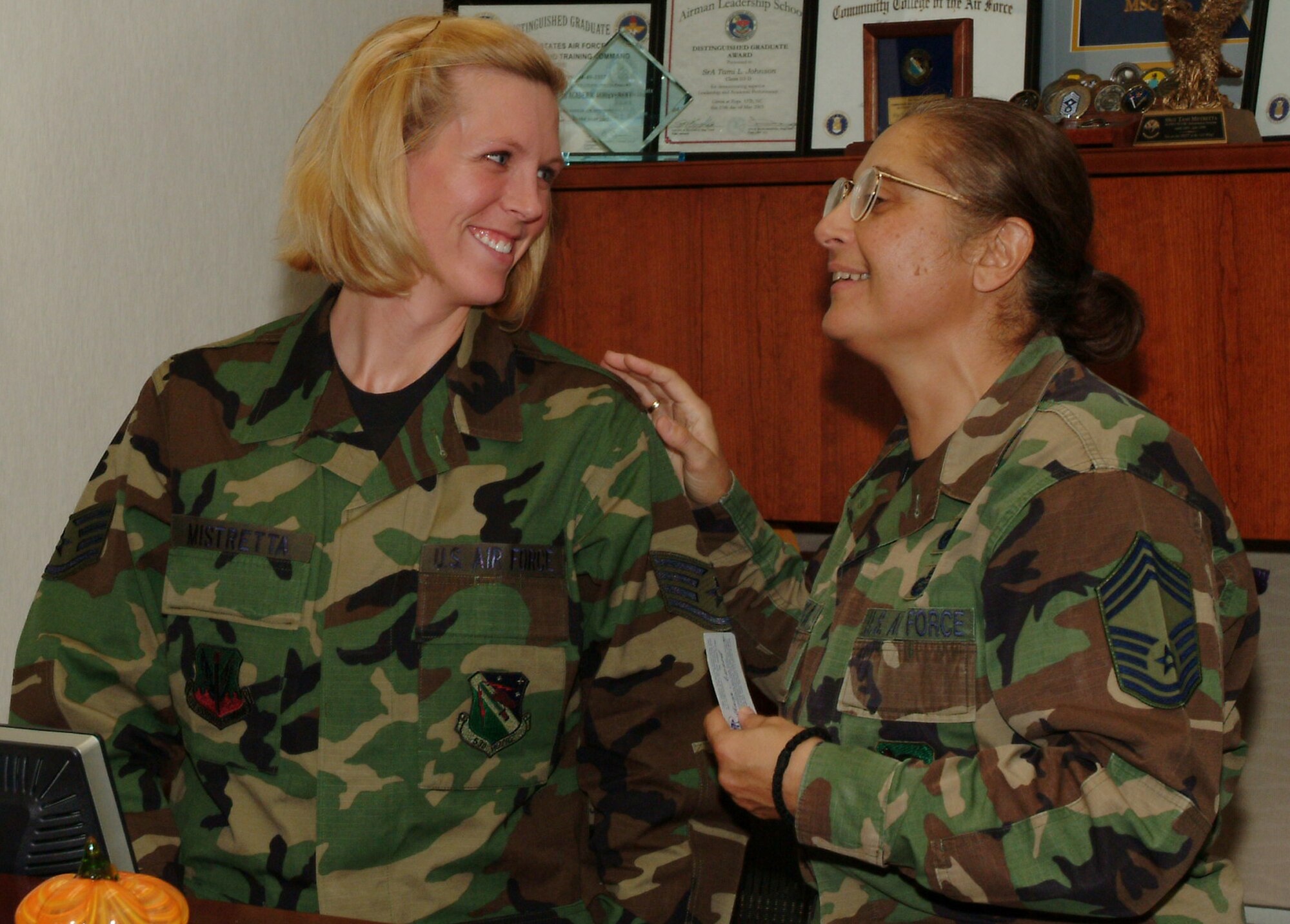Staff Sgt. Tami Mistretta, wing staff, receives a congratulations from Chief Master Sgt. Aphrodite Kafka, 96th Manpower, for being named the Chief’s Group sharp troop.  Chief Kafka, who worked with Sergeant Mistretta at the 332nd Expeditionary Mission Support Group in Balad, knew she was a good choice for the honor.  
“As a new staff sergeant and new to the career field, she worked wonders at the group in a very hostile area,” said the chief.  “She even managed to be the secretary of the 5-6 group in Balad.  
"Since she’s been here, I’ve heard nothing but great things from her supervision, and she was recently hand-picked to work at the wing for the command chief,” she said.  “She epitomizes the Air Force core value of service before self.”  (Photo by Tech. Sgt. Andrew Leonhard.)