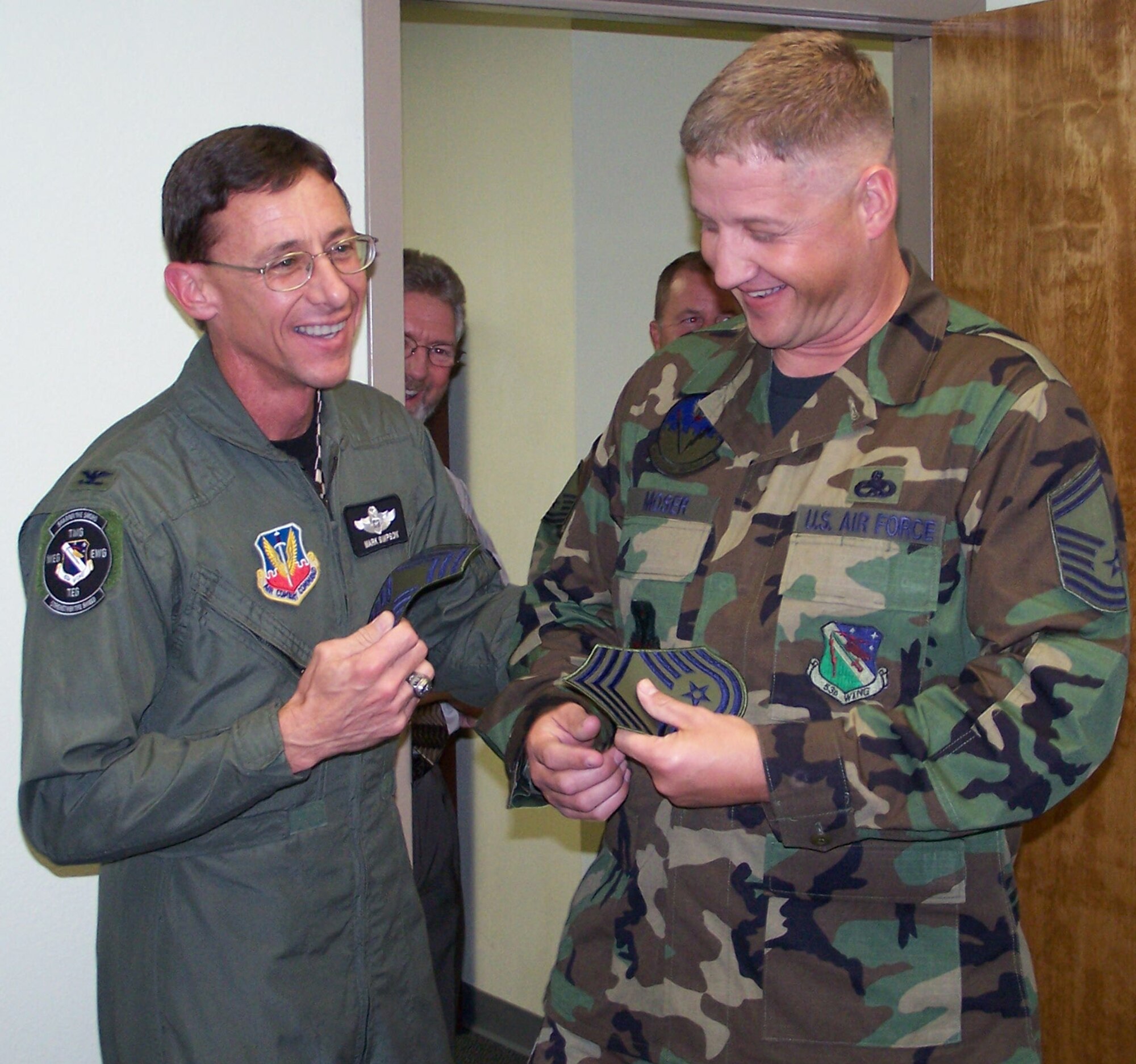 Senior Master Sgt. Neal Moser, 53d Electronic Warfare Group, reacts to finding out he made chief as Col. Mark Simpson, 53d Wing commander, (left) presents him with his new stripes and a congratulations.  (Photo by Master Sgt. Roy Grubbs)