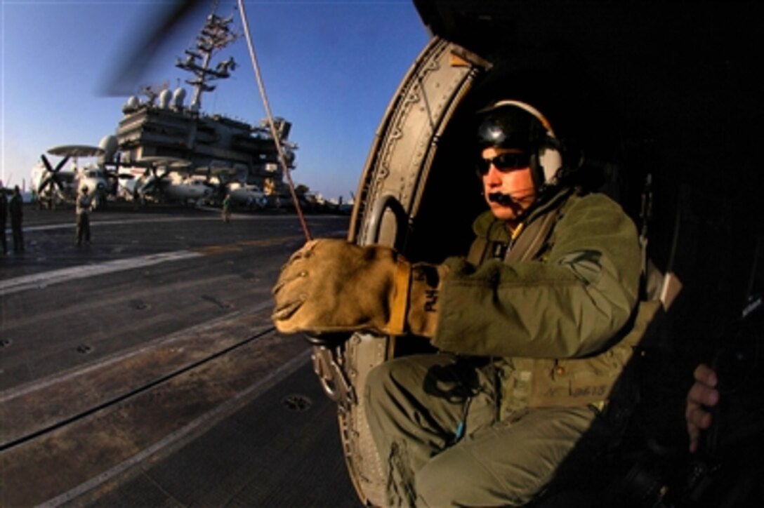 U.S. Navy Petty Officer 2nd Class Michael McKnight performs a preflight check on a double rescue hook aboard a HH-60H Seahawk helicopter from Helicopter Antisubmarine Squadron prior to the start of flight operations aboard USS Kitty Hawk, Nov. 14, 2006. 