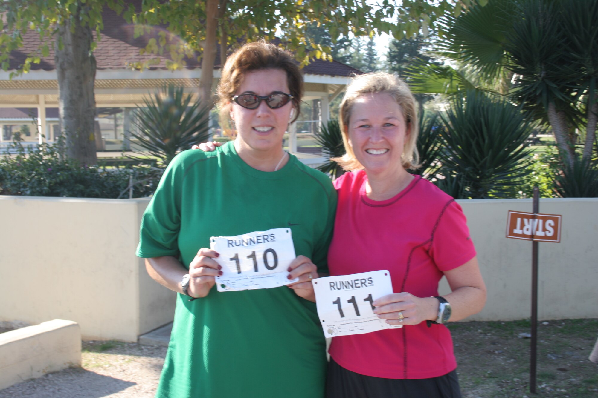Nicole Kulas (left) and Emily Ozgul hold up their half marathon numbers after finishing the race.  Both women have been training for the half marathon for more than nine weeks. This is Mrs. Kulas' fourth half marathon and Mrs. Ozgul's first. They finished just over two hours. (U.S. Air Force photo by Senior Airman Patrice Clarke)
