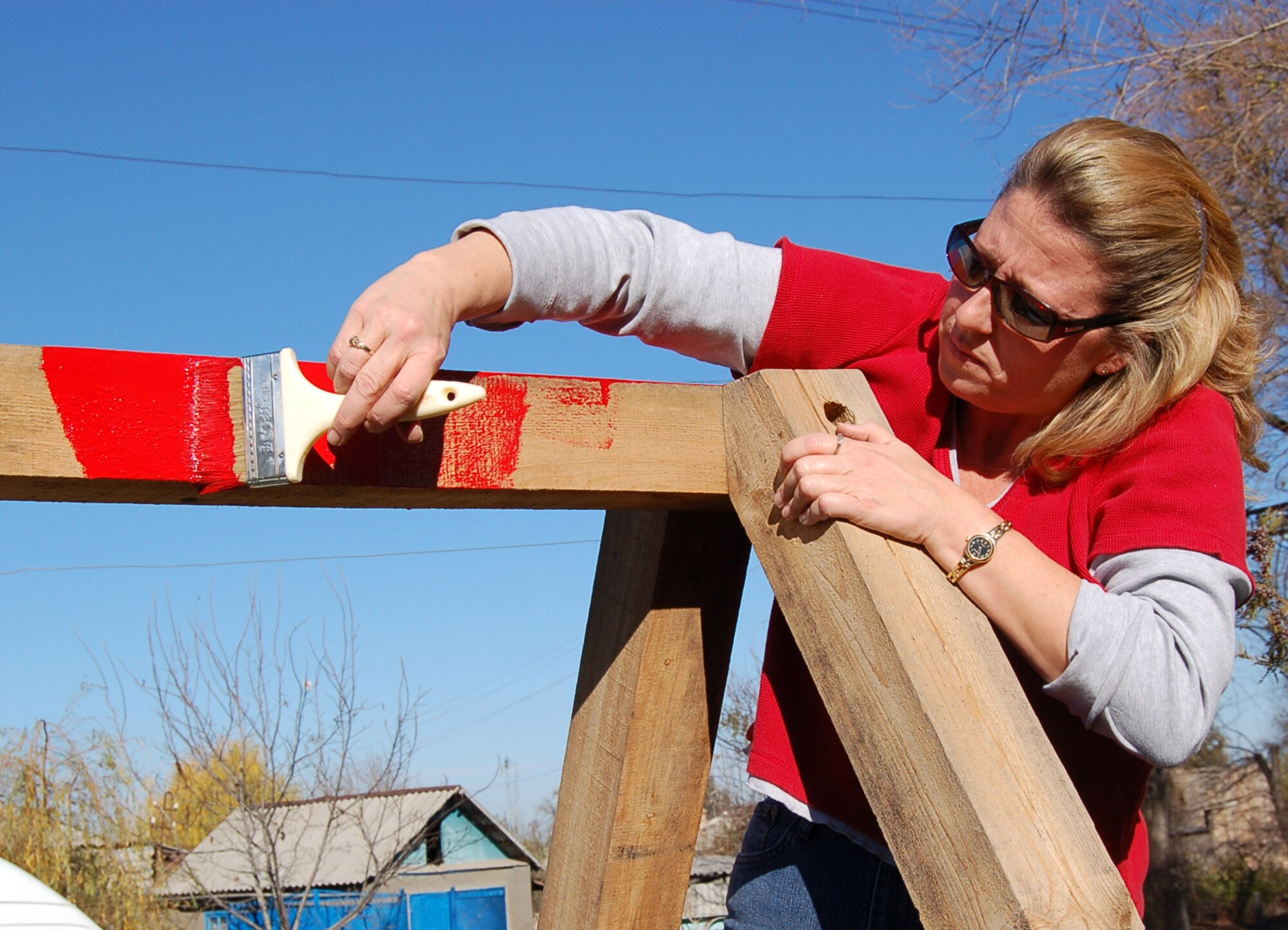 Master Sgt. Barbara Holley, 376th Air Expeditionary Wing administrator, begins painting the top beam of a swing set built for local kindergarteners by the previous rotation. Members of both the 376th AEW and Expeditionary Operations Group visited the Solnyshko Kindergarten School near the village of Vinogradnoe, Kyrgyzstan, Nov. 16 to complete the swing set for the children. Sergeant Holley is deployed from the 32nd Aerial Port Squadron, Pittsburgh, Pa. (U.S. Air Force Photo/Capt. Christy Stravolo)