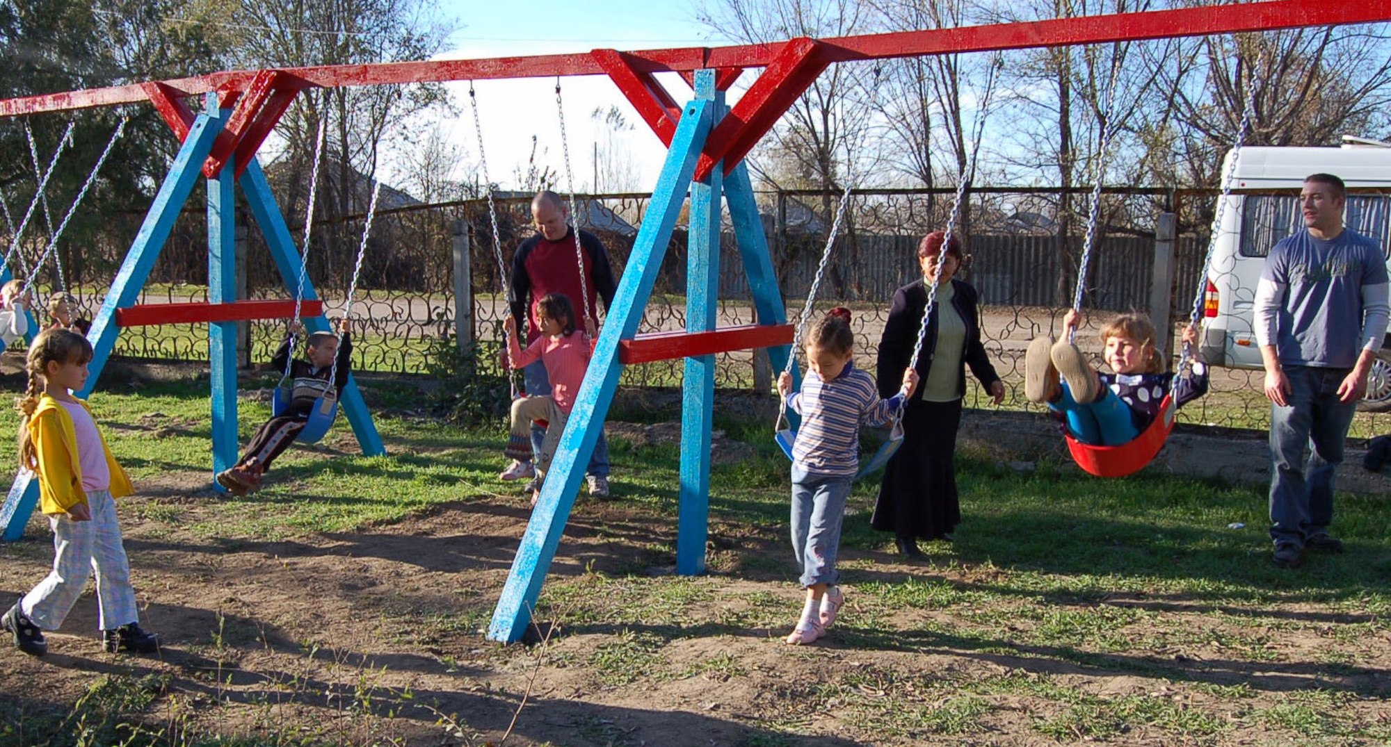 Pushing the children on their new swing set from left to right: Capt. Chad Wright, 376th Air Expeditionary Wing sexual assault response coordinator; Solnyshko Kindergarten School principal, Manzura Kushbaeva; and Airman First Class Andrew Purpura, 376th Expeditionary Operations Support Squadron intel analyst. Manas Airmen will return to the school in the coming weeks to install a sink with running water in the school kitchen. Capt. Wright is deployed from the 341st Space Wing at Malmstrom Air Force Base, Mont., and Airman Purpa is deployed from the 92nd OSS at Fairchild AFB, Wash. (U.S. Air Force Photo/Capt. Christy Stravolo)