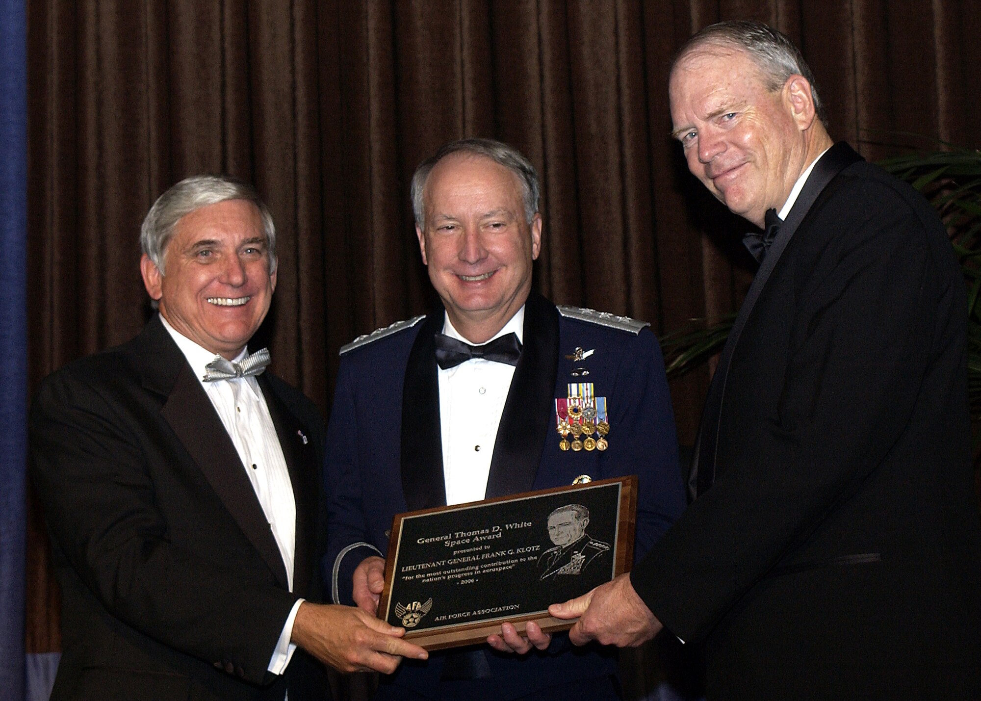 LOS ANGELES -- Retired Lt. Gen. Brian Arnold (right), chairman of the board, Gen. Bernard A. Schriever Chapter, Air Force Association; and Mr. Robert E. "Bob" Largent, AFA National Chairman of the Board (left), present the 2006 General Thomas D. White U.S. Air Force Space Trophy to Lt. Gen. Frank Klotz, vice commander of Air Force Space Command, during the AFA's National Symposium on Space and Air Force Ball here Nov. 17.  (U.S. Air Force photo by Duncan Wood) 

