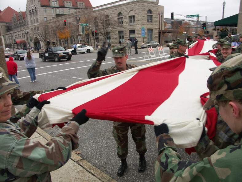 "March it that way ladies and gentlemen"...Patriotism is important to this Airman as he secures the American Flag.  Veterans were honored by members of the 932nd Airlift Wing, Air Force Reserve Command, located at Scott Air Force Base, Ill.  They marched their huge American flag through the streets of Saint Louis on a cold, blustery, November day.  Photo/Capt. Stan Paregien
