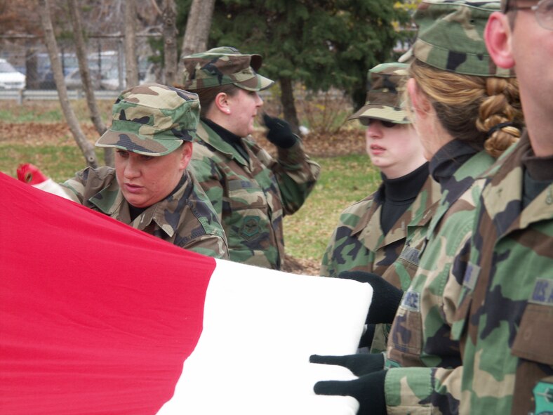 A member of the 932nd Airlift Wing Honor Guard starts the flag folding.  Veterans were honored by members of the 932nd Airlift Wing, Air Force Reserve Command, located at Scott Air Force Base, Ill.  They marched their huge American flag through the streets of Saint Louis on a cold, blustery, November day.  Photo/Capt. Stan Paregien

