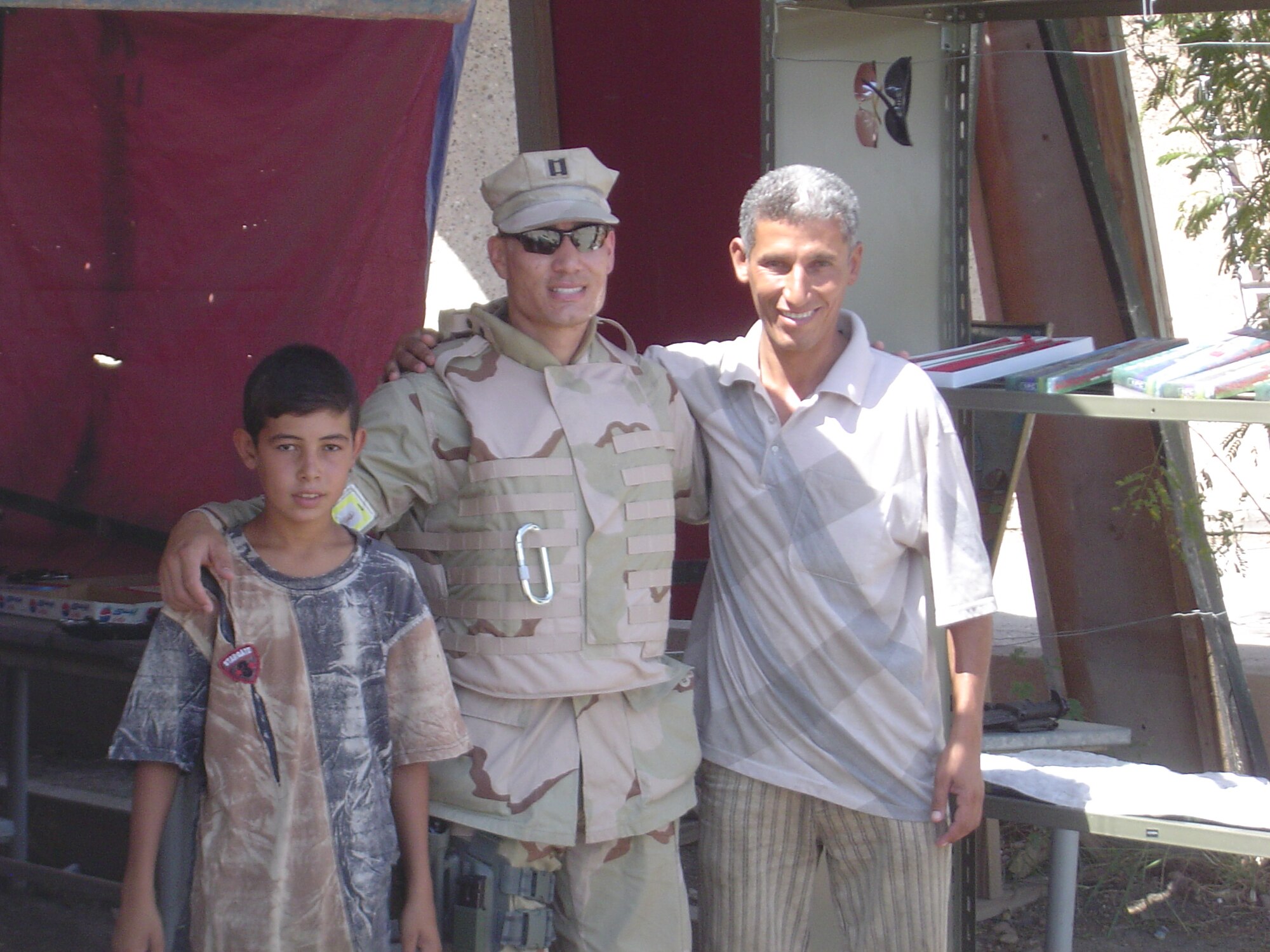 (Courtesy photo) Capt. David Huinker, 71st Medical Group medical logistics flight commander, poses with two Iraqis at a store in Iraq. Captain Huinker is performing security duties during his deployment.