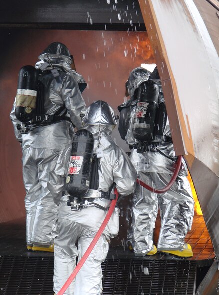 (Photo by Capt. Tony Wickman) Colonel Benson, Colonel Thelen and a Vance firefighter make their way through the burning aircraft at the airfield rescue firefighting training facility. 