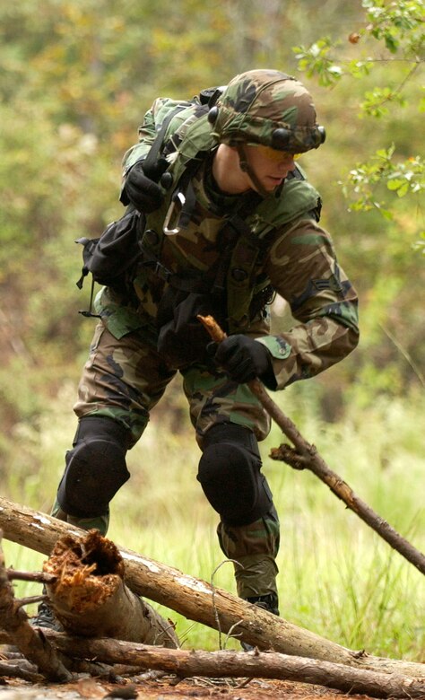Airman 1st Class Brian Boyette, 30th Space Communications Squadron, simulates a breach and clears logs and debri along the roadside during convoy training at the North Auxillary Field, S.C., Oct. 18, 2006. The ATSO training was held by the 1st Combat Camera Squadronand is an annual exercise designed to train Airmen for real world contingencies and combat operations. (U.S. Air Force photo by Airman 1st Class Christopher Hubenthal)                           