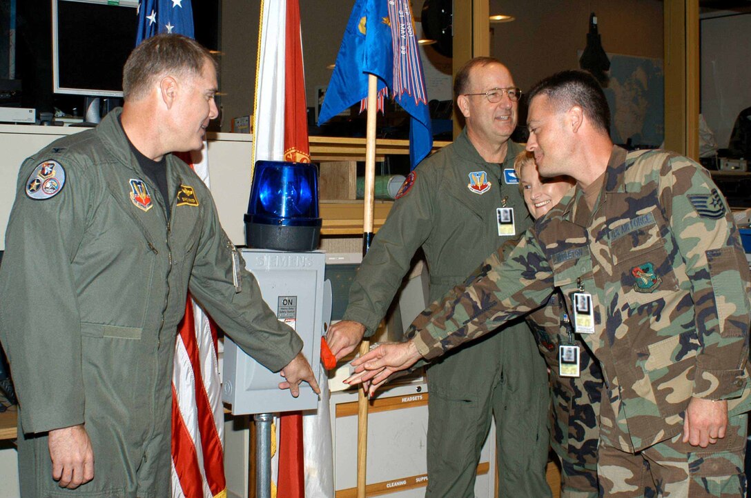 Colonel David Kriner (left) 601 AOC commander, flips the ceremonial switch with (right) Maj. Gen. Hank Morrow, 1st Air Force commander, and SEADS Master Sgt Judy Butler-McGuire and Tech Sgt James Middleton. The ceremony marked the closure of operations at SEADS and its continued transition to the 601st Air Operations Center. (Photo by Deb Kiser) 
