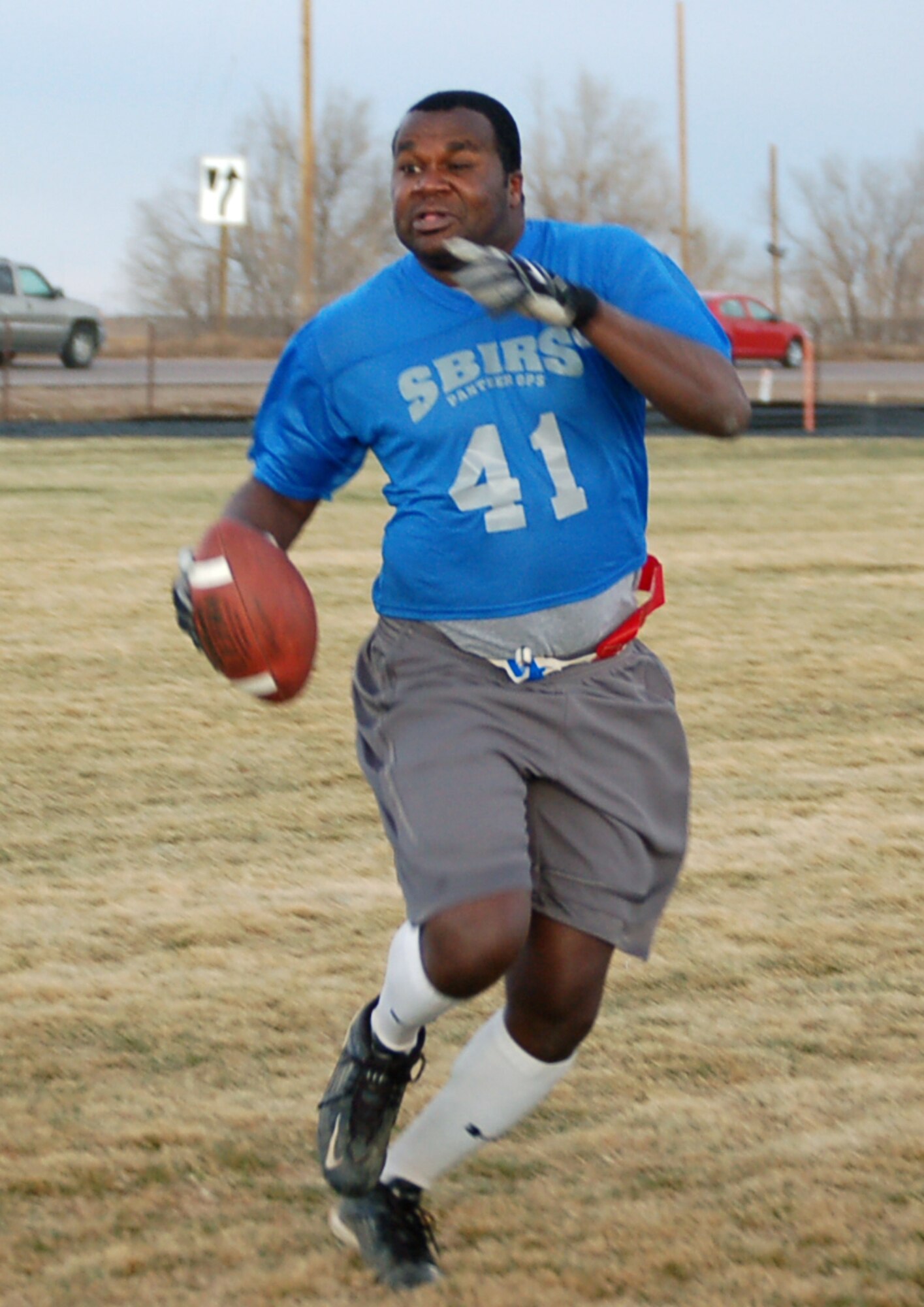 460th Operations Support Squadron/2nd Space Warning System quarterback Calvin Pennamon runs the ball during the intramural flag football game against the 566th Information Operations Squadron. The 566th IOS shut out the 460th OSS/2nd SWS 13-0.