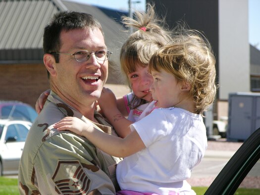 PETERSON AIR FORCE BASE, Colo. (AFRC) -- Recently promoted Senior Master Sgt. Michael Fekete, 302nd Maintenance Squadron integrated avionics systems craftsman, holds his daughters, Morgan (center) and Courtney, during a recent homecoming. (U.S. Air Force photo by Master Sgt. Mark Clark)