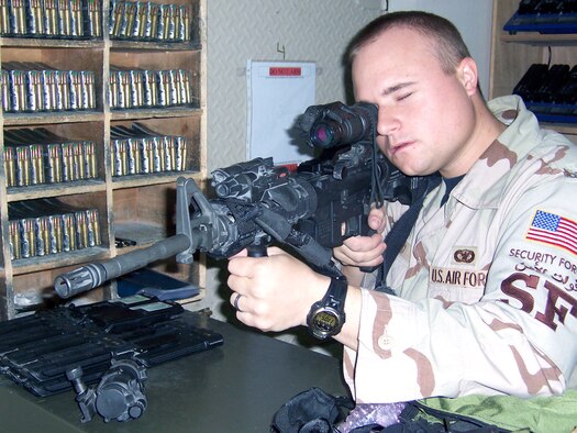 Senior Airman Creg Kinkead tests a pair of night-vision goggles, using a kit to mount it on an M4. The "Vital 2," located in front of the weapon, shoots out an infrared laser invisible to the eye. Airman Kinkead is a 379th Expeditionary Security Forces Squadron armory room attendant. (U.S. Air Force photo/Tech. Sgt Steve Staedler) 