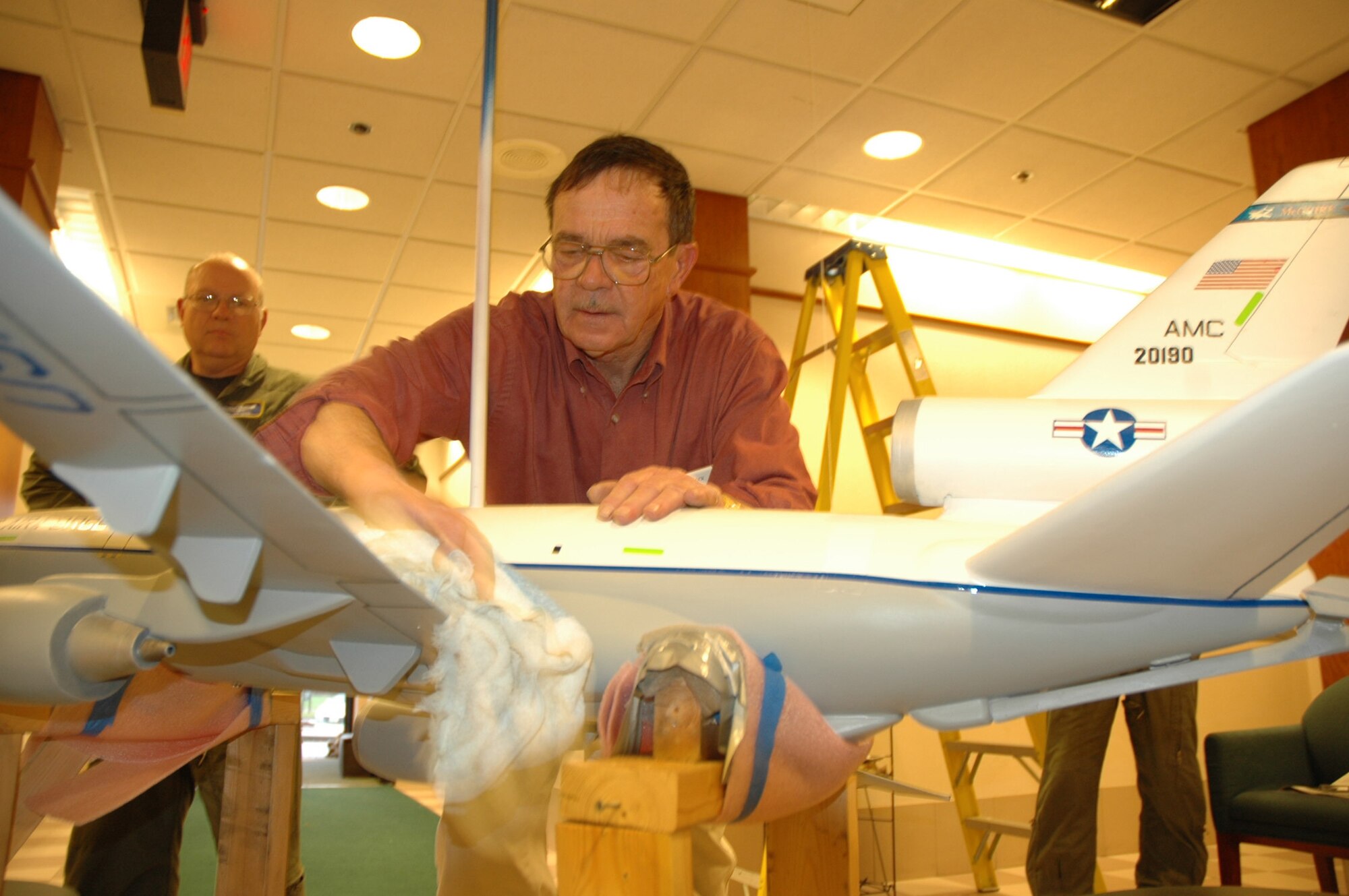 Herb Corder, U.S. Air Force veteran, readies the KC-10 Extender model he spent more than 140 hours rebuilding before its rehung from the ceiling at the Reserve KC-10 building on McGuire Air Force Base, N.J. The model aircraft has many new features its original model, that was damaged five years ago, did not have to include working exterior lights. (U.S. Air Force photo/Master Sgt. Donna T. Jeffries)