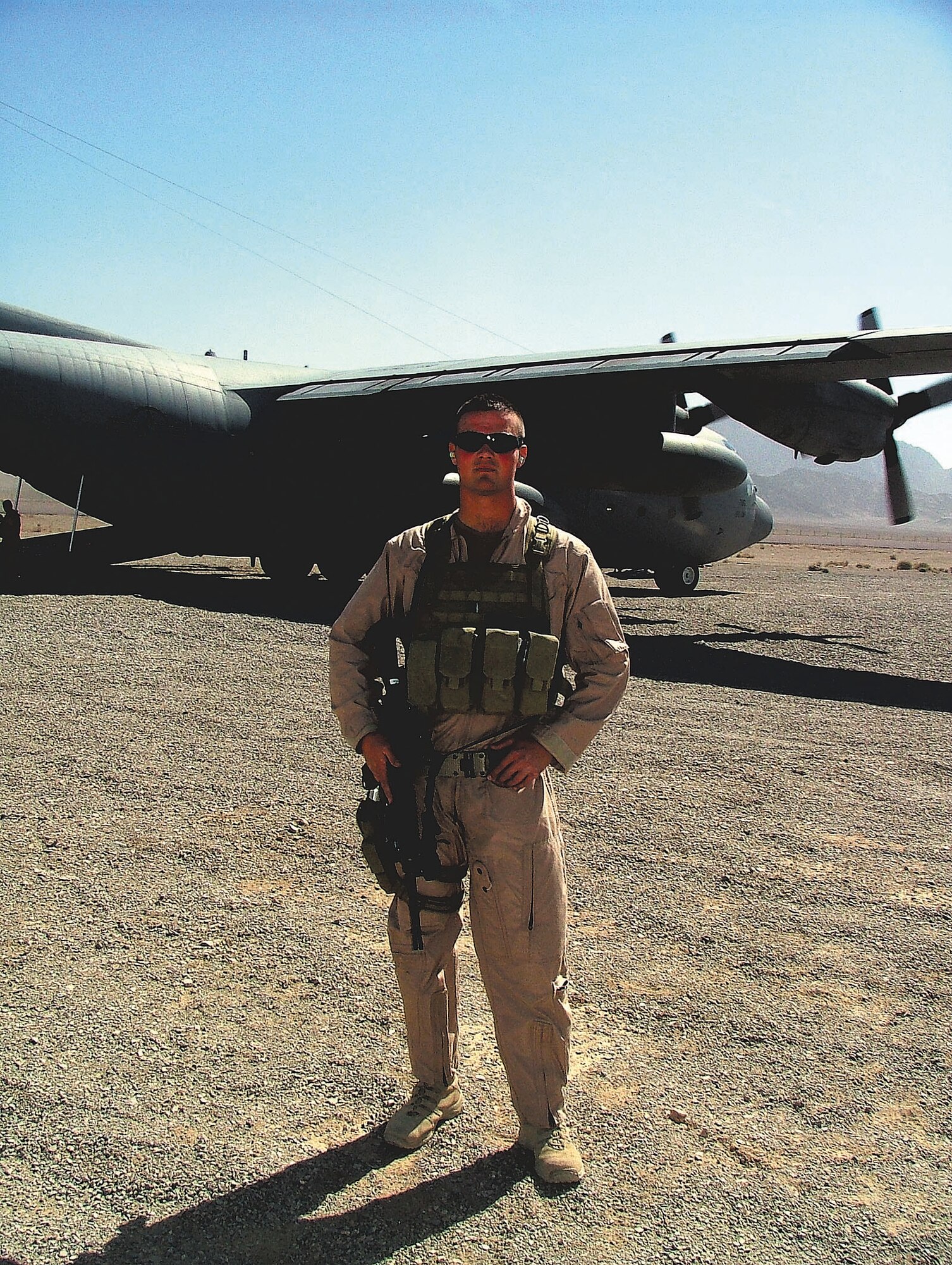 Senior Airman Kyle Battell, deployed from the 28th Security Forces Squadron, Ellsworth AFB, S.D., secures an avenue of approach from potential adversaries for a C-130 Hercules. Airman Battell is one of nine security forces members from Ellsworth who received fly away security team training prior to deploying. This aircraft is off loading cargo at an undisclosed location in Afghanistan. (Courtesy photo)