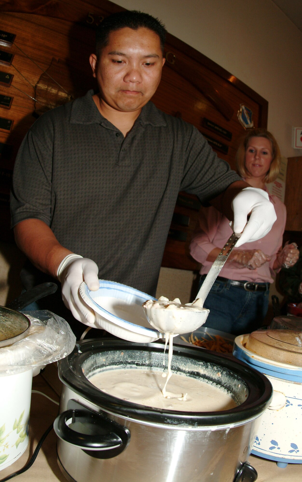 Tech. Sgt. Thavone Vinthaxay, 53d Wing Staff Booster Club president, serves up some chowder during the club’s soup and salad fundraiser Nov. 9.  The fundraiser, planned by Kathy Thompson and Jackie Brown-Allen, grossed $475, which included money raised from active-duty donations to wear civilian attire for the day. (Photo by Tech. Sgt. Andrew Leonhard.)    