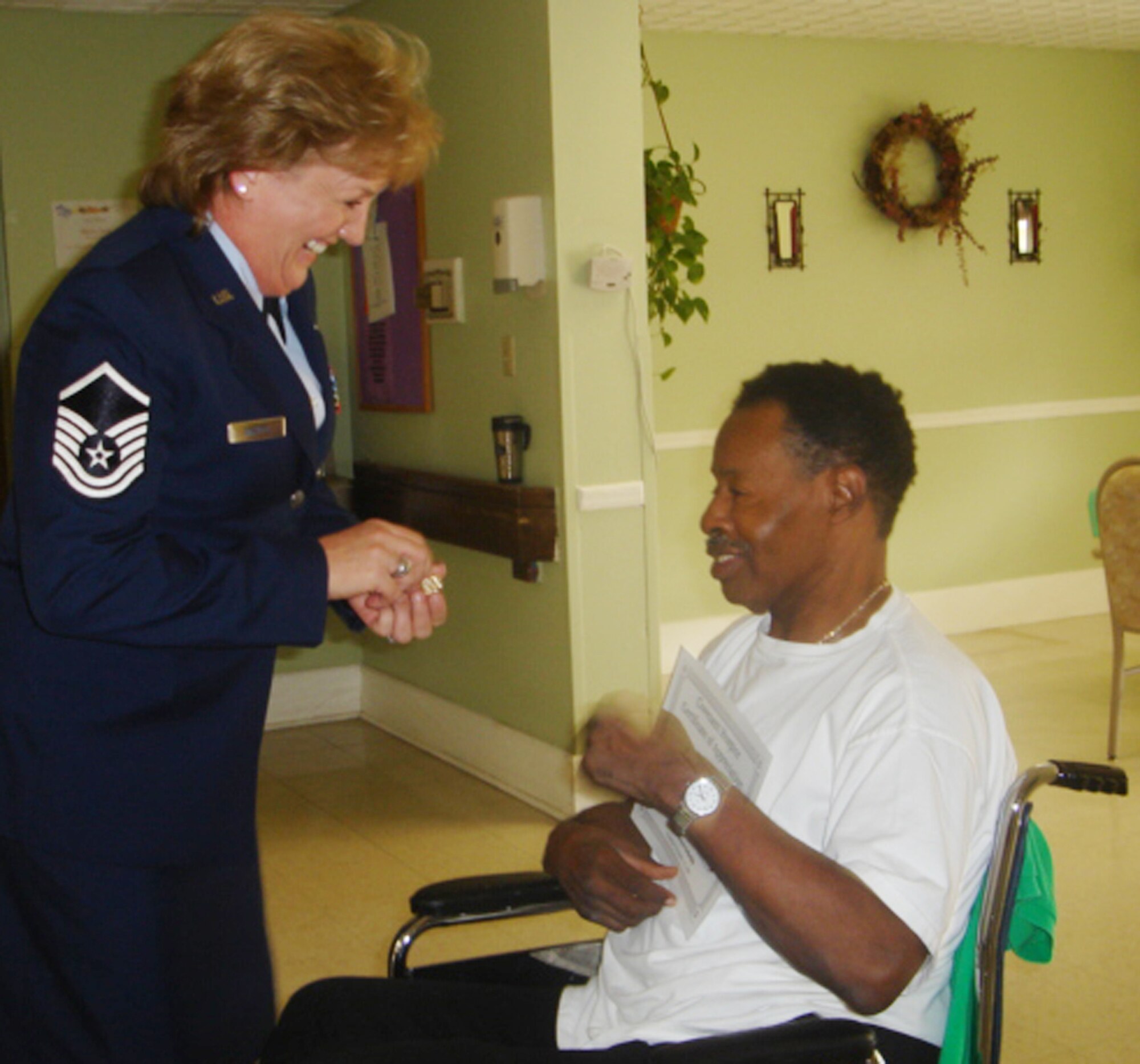 Master Sgt. Lisa Casteel, wing staff, shares a laugh with one of the veterans she met Nov. 10 at Parthenon Health Care.