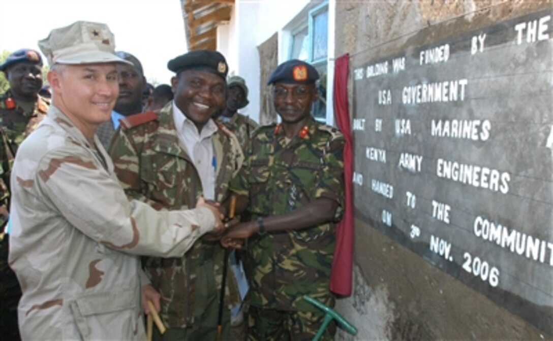 U.S. Navy Rear Adm. Tim Moon, deputy commander of Combined Joint Task Force - Horn of Africa and Kenyan army Brig. Gen. Leornard Ngondi celebrate the opening of the East African nomadic community primary school in Riongo, Kenya, Nov. 3, 2006. The school was built by the Kenyan Department of Defense and Combined Joint Task Force - Horn of Africa.