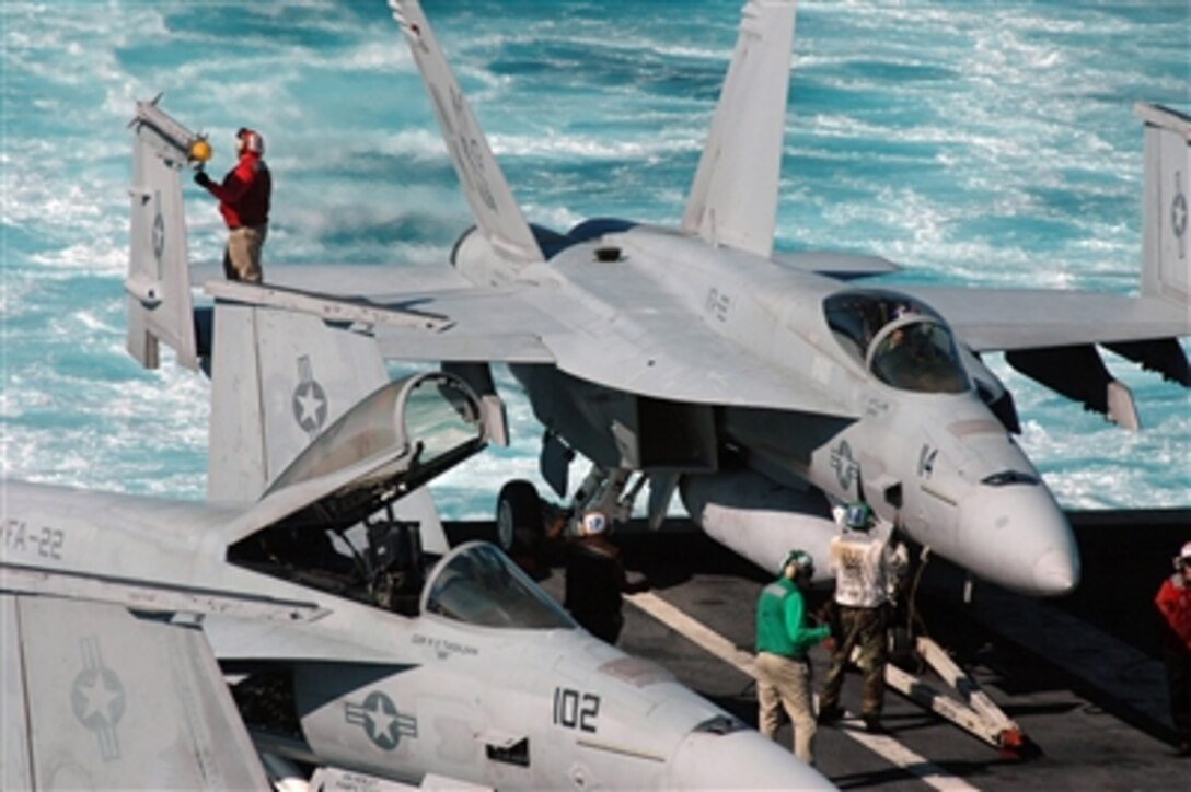 A U.S. Navy aviation ordnanceman (left) conducts a post-flight weapons check of a training weapon aboard an F/A-18E Super Hornet aircraft after a flight evolution on the aircraft carrier USS Ronald Reagan (CVN 76) on Nov. 16, 2006.  The Reagan is under way conducting routine carrier operations off the coast of Southern California.  