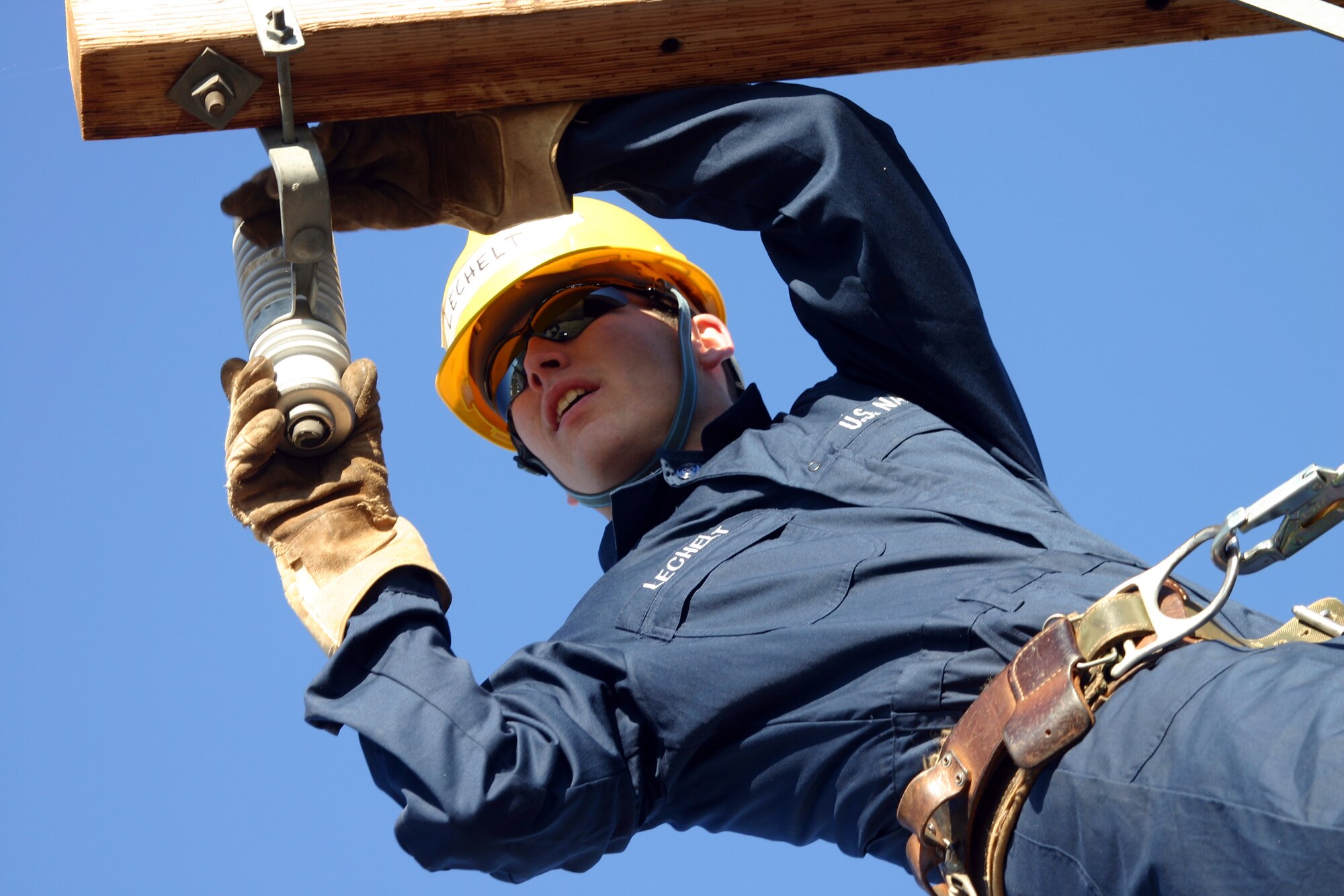 Navy Seaman David Lechelt changes out a lightning arrestor during the Student Lineman’s Rodeo Saturday. (U.S. Air Force photo/Airman Jacob Corbin).