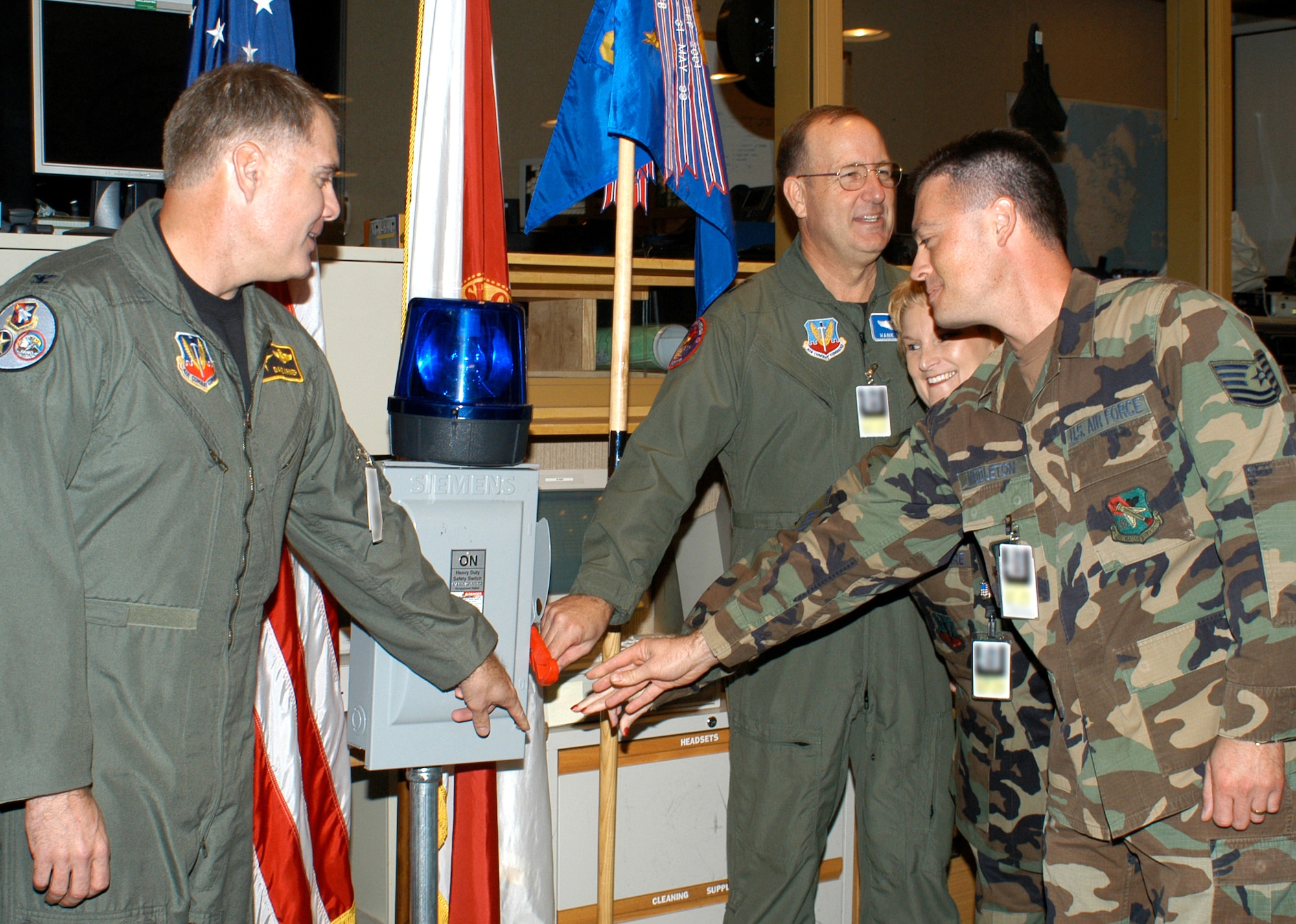 Col. David Kriner flips the ceremonial switch with (right) Maj. Gen. Henry C. "Hank" Morrow and Southeast Air Defense Sector technicians Master Sgt. Judy Butler-McGuire and Tech. Sgt. James Middleton. The ceremony marked the closure of operations at SEADS and its continued transition to the 601st Air Operations Center. Colonel Kriner is the 601st Air Operations Center commander, General Morrow is the 1st Air Force commander. (U.S. Air Force photo/Deb Kiser)