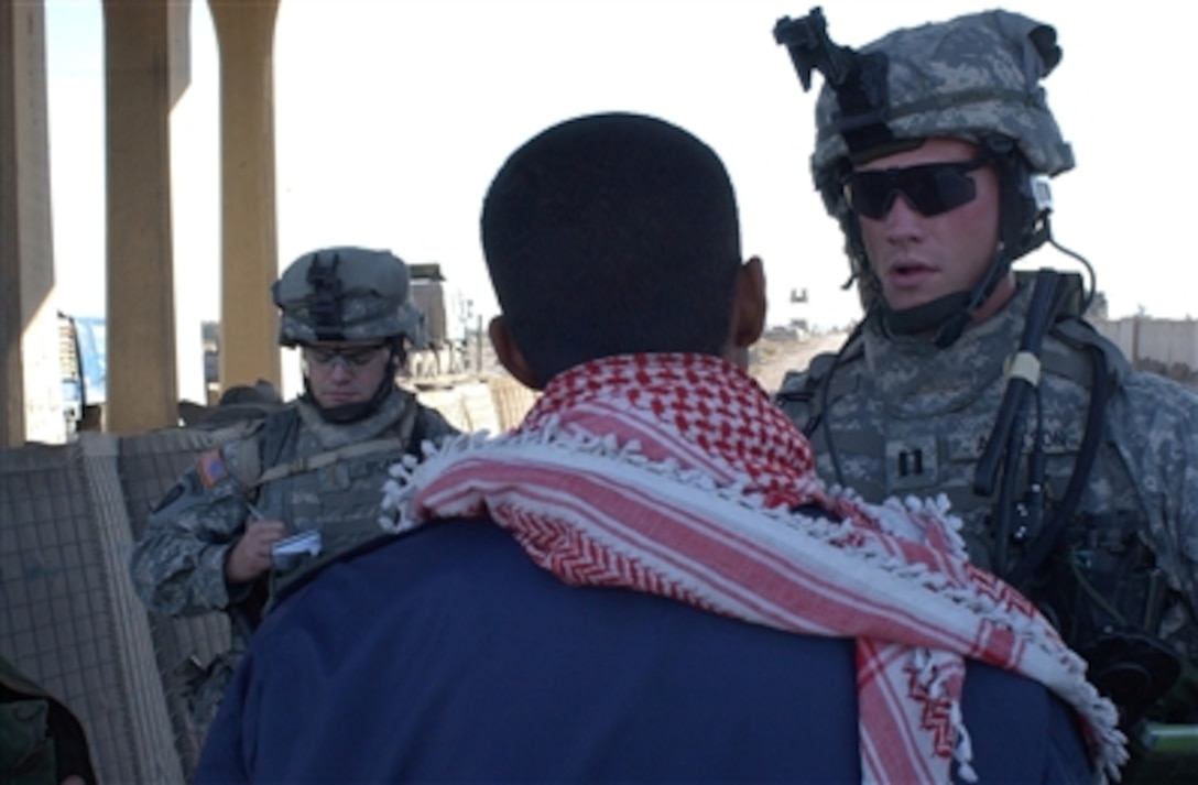 U.S. Army Capt. Edward Arntson (right) talks with an Iraqi policeman from the highway patrol at a checkpoint in Iraq on Nov. 16, 2006.  Arntson is Alpha Company commander, of 3rd Battalion, 509th Infantry Regiment, 4th Brigade Combat Team, 25th Infantry Division.  