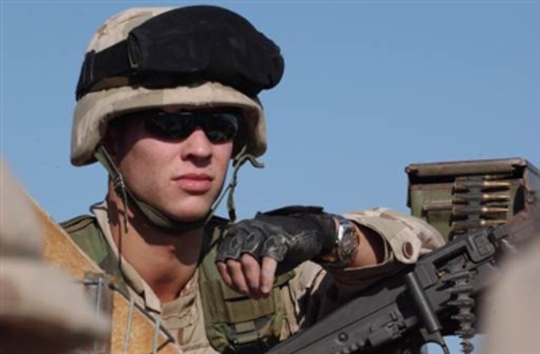Latvian army Pvt. Vitalijs Grigorjevs, from the Maneuver Group, Multinational Division Central South, Camp Echo, provides security while other team members change a flat tire on their Humvee during a mounted patrol in Ad-Diwaniyah, Iraq, Nov. 16, 2006.