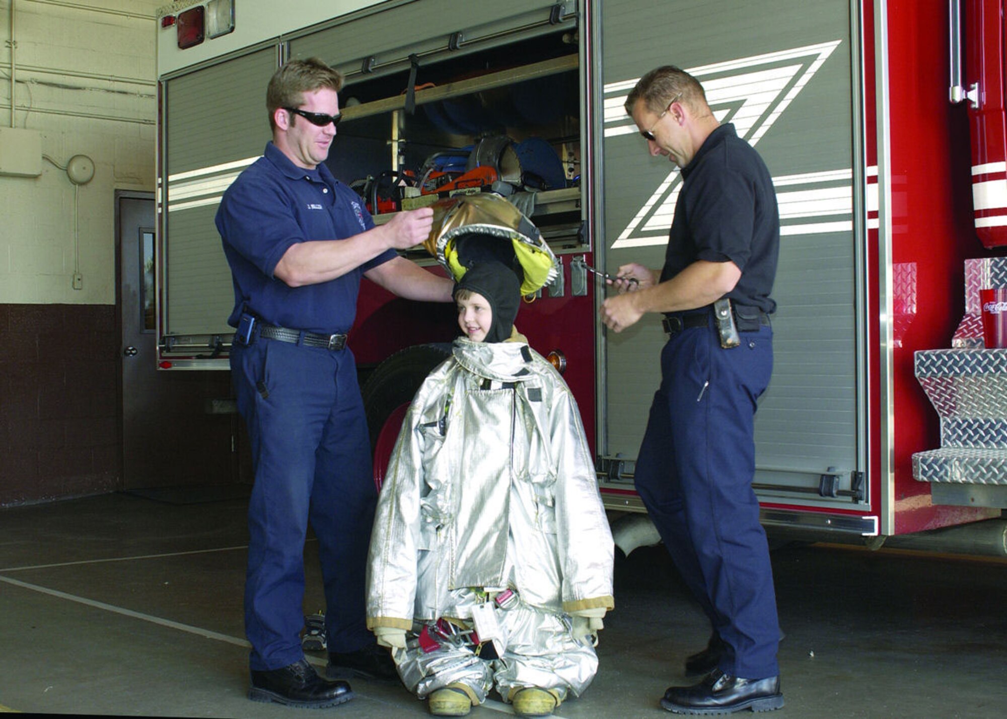 Reilly Koyl dons his fireman suit as Edwards' firefighters give him a helping hand. Reilly was diagnosed with leukemia when he was 2 years old and just finished three years of chemotherapy. (Photo by Mark McCoy)
