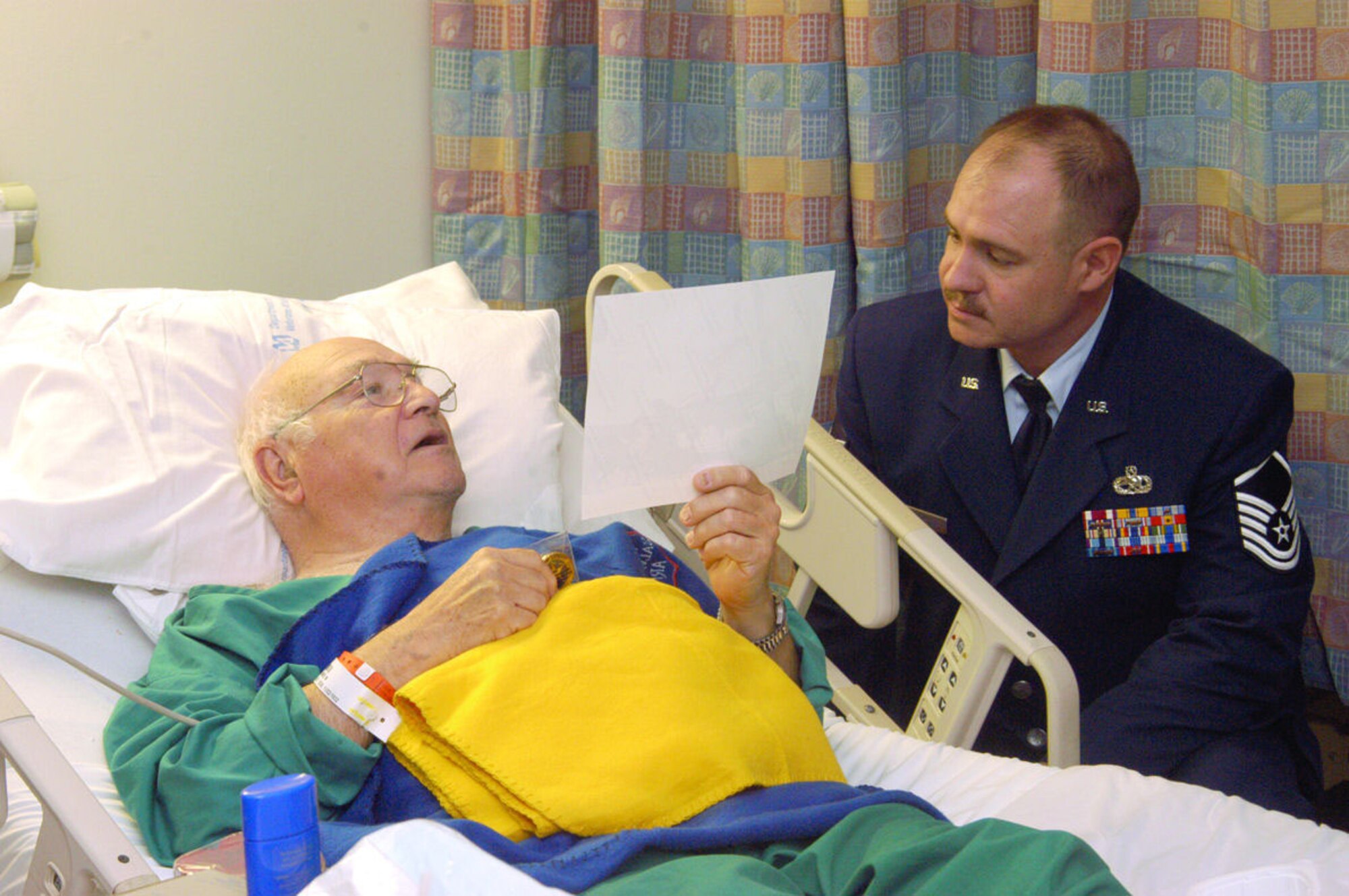 Master Sgt. Owen McCallister, 412th Equipment Maintenance Squadron, visits with a veteran at the West Los Angeles Veterans Affairs Healthcare Center on Feb. 14, 2006. During the visit, participants gave out everything from Valentines bears and cards to chocolates to the veterans at the healthcare center. (Photo by Senior Airman Jet Fabara)