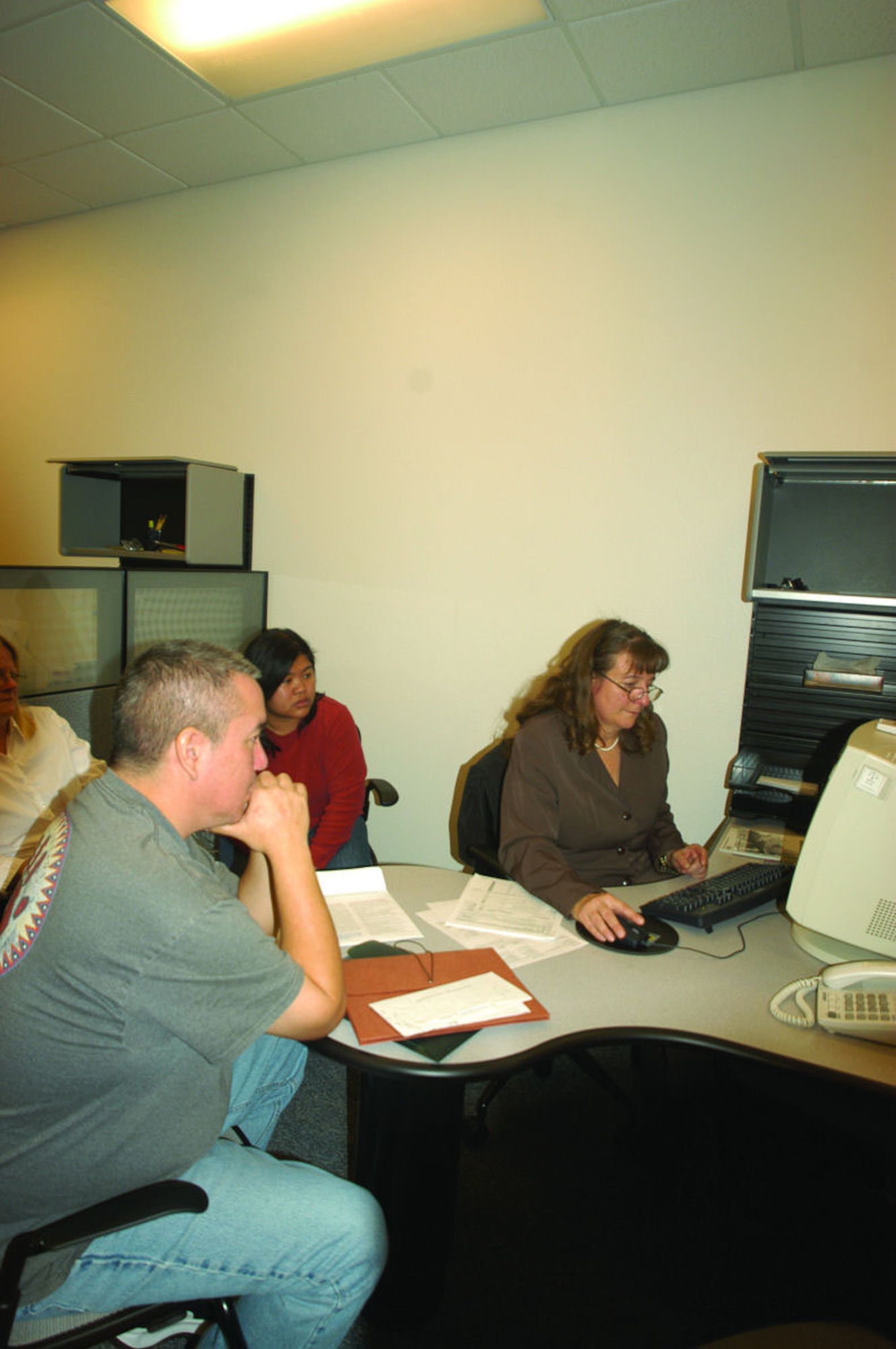 Edwards Tax Center volunteer Janet Fitzgerald (right) assists customers in preparing and filing their income tax returns. (Photo by Airman 1st Class Julius Delos Reyes)