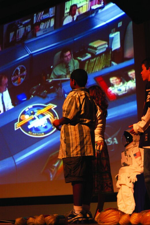 Base students prepare to ask questions with Mission Control before connecting with the crew of the International Space Station as part of the NASA Explorer School program, March 2, 2006, in the base theater. (Photo by Airman 1st Class Julius Delos Reyes)