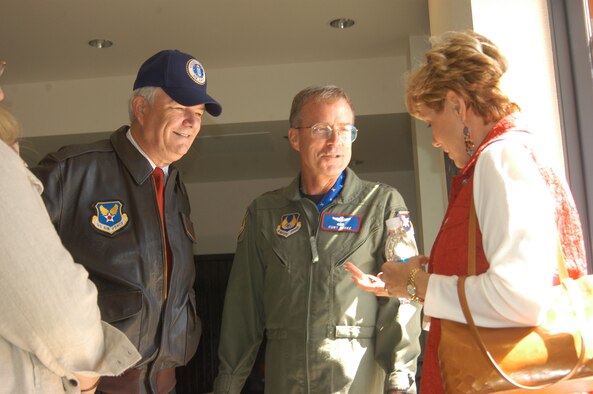 Secretary of the Air Force Michael W. Wynne (left) looks on while Maj. Gen. Curtis Bedke, Air Force Flight Test Center commander, presents an AFFTC coin to the Secretary's wife, Barbara, Sept. 21, 2006, at Base Operations here. Secretary Wynne visited the base to observe the progress on alternative fuel testing that took place here Sept. 19. (Photo by Staff Sgt. Mark Woodbury)